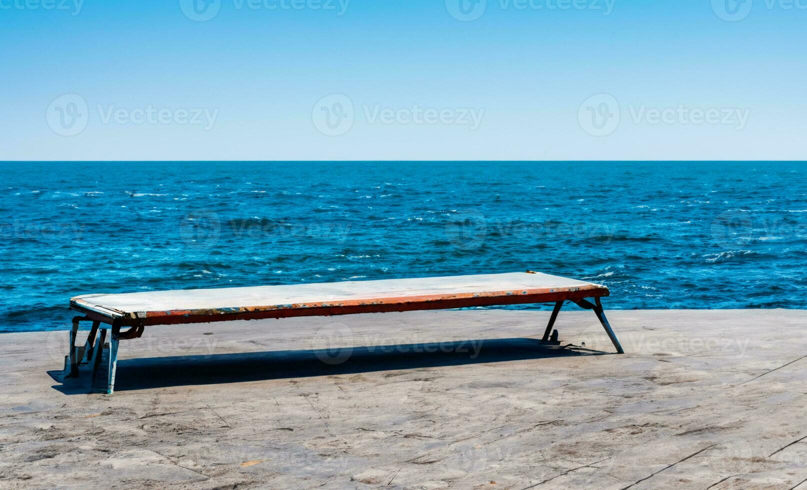 AI generated a stone bench sitting on top of a wall overlooking the ocean photo