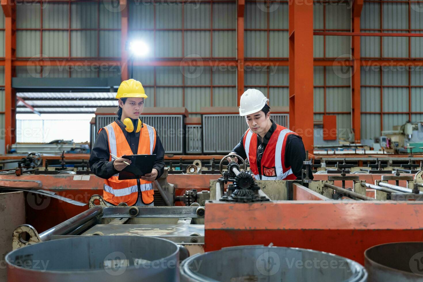 Team of Asian industrial worker is checking setup value of the metal sheet roll forming machine by automated monitor while working inside roof factory for safety industry photo