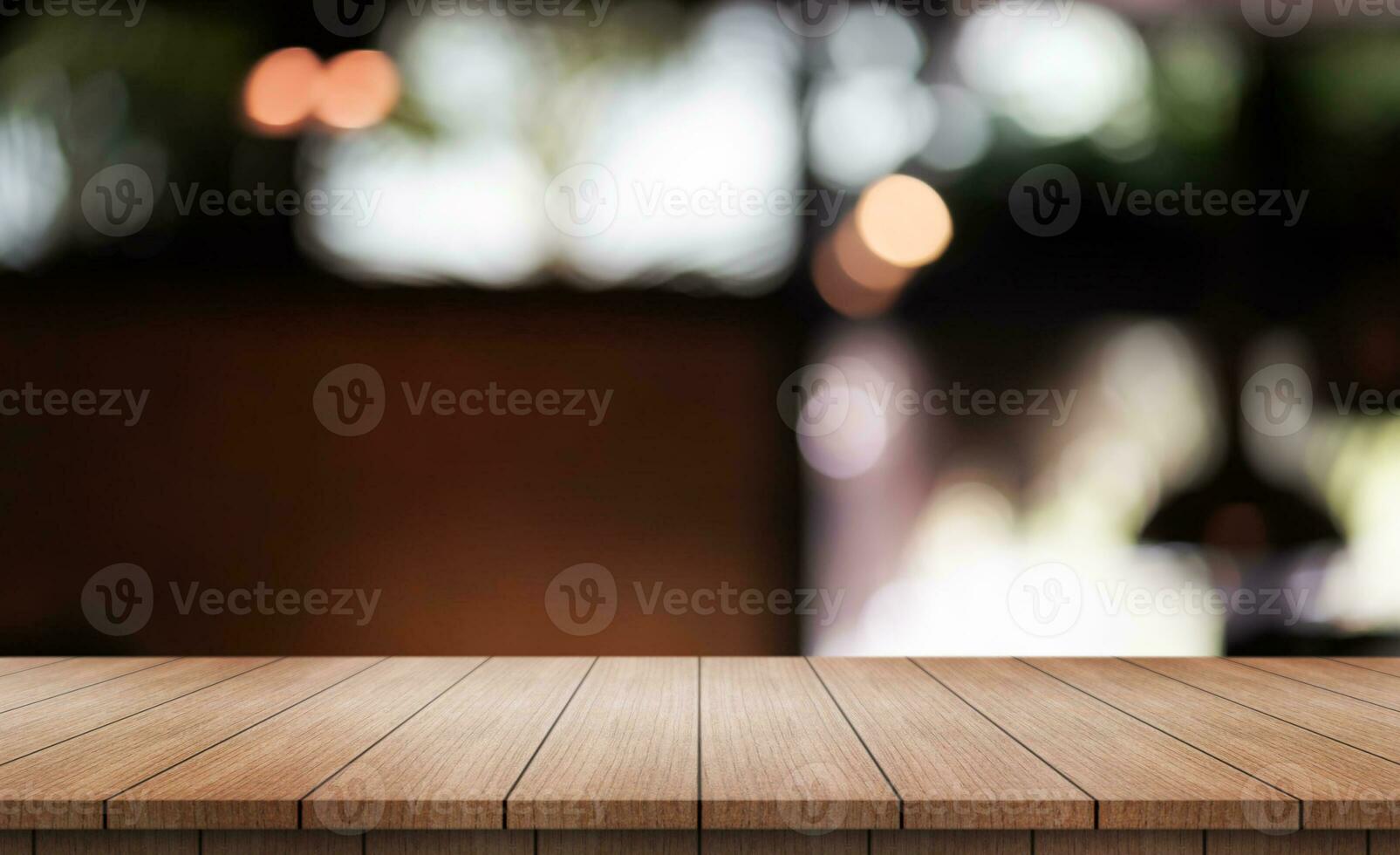 Empty wooden table top with lights bokeh on blur restaurant background. photo