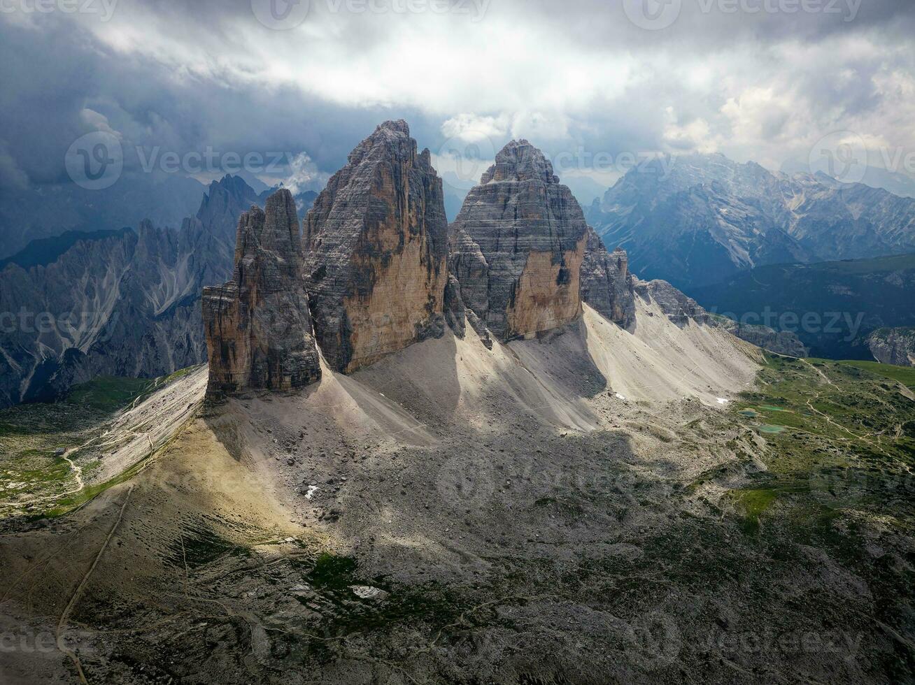 Aerial view of Tre Cime di Lavaredo mountain during a cloudy day with few sun openings in the Dolomites, Italy. Dramatic and cinematic landscape. very famous places for hiking and rock climbing. photo