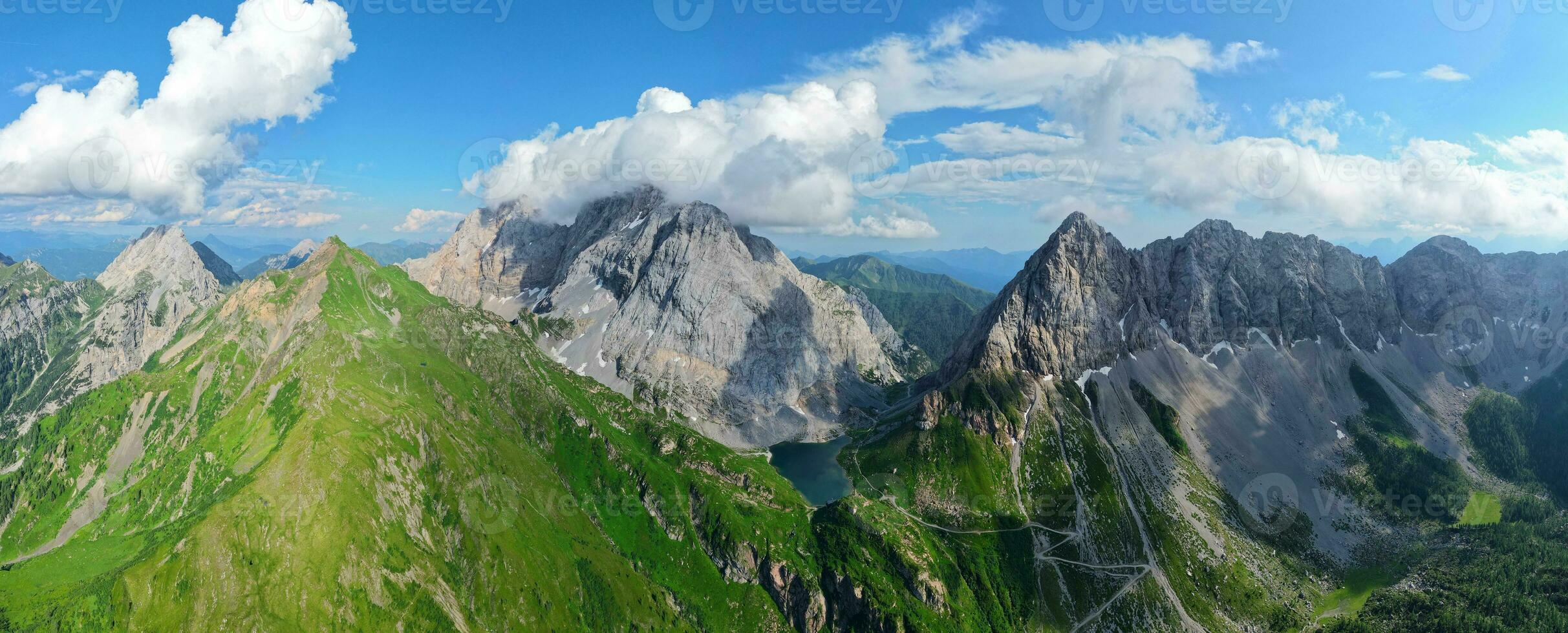 aéreo panorámico ver de volaya lago, wolayersee, en el frontera de Italia y Austria con coglianos montaña en el antecedentes. nublado día con algunos Dom apertura. vibrante colores. foto