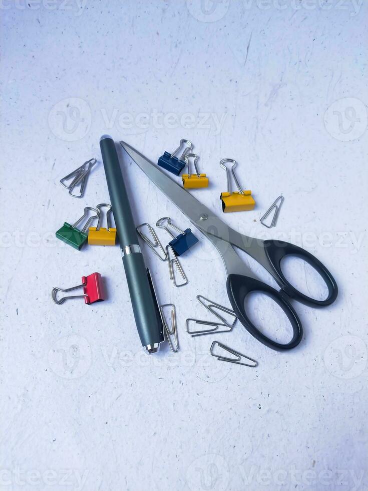 Stationery, scissors and binder clips on a white background. photo