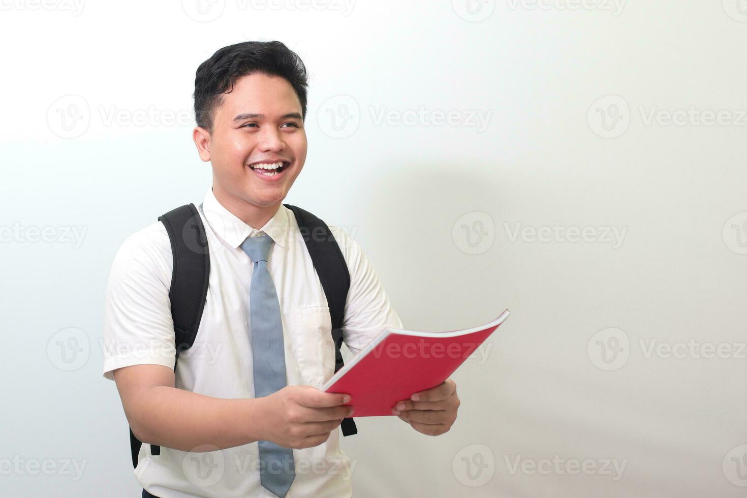 Indonesian senior high school student wearing white shirt uniform with gray tie submitting his journal report to someone for approval. Isolated image on white background photo