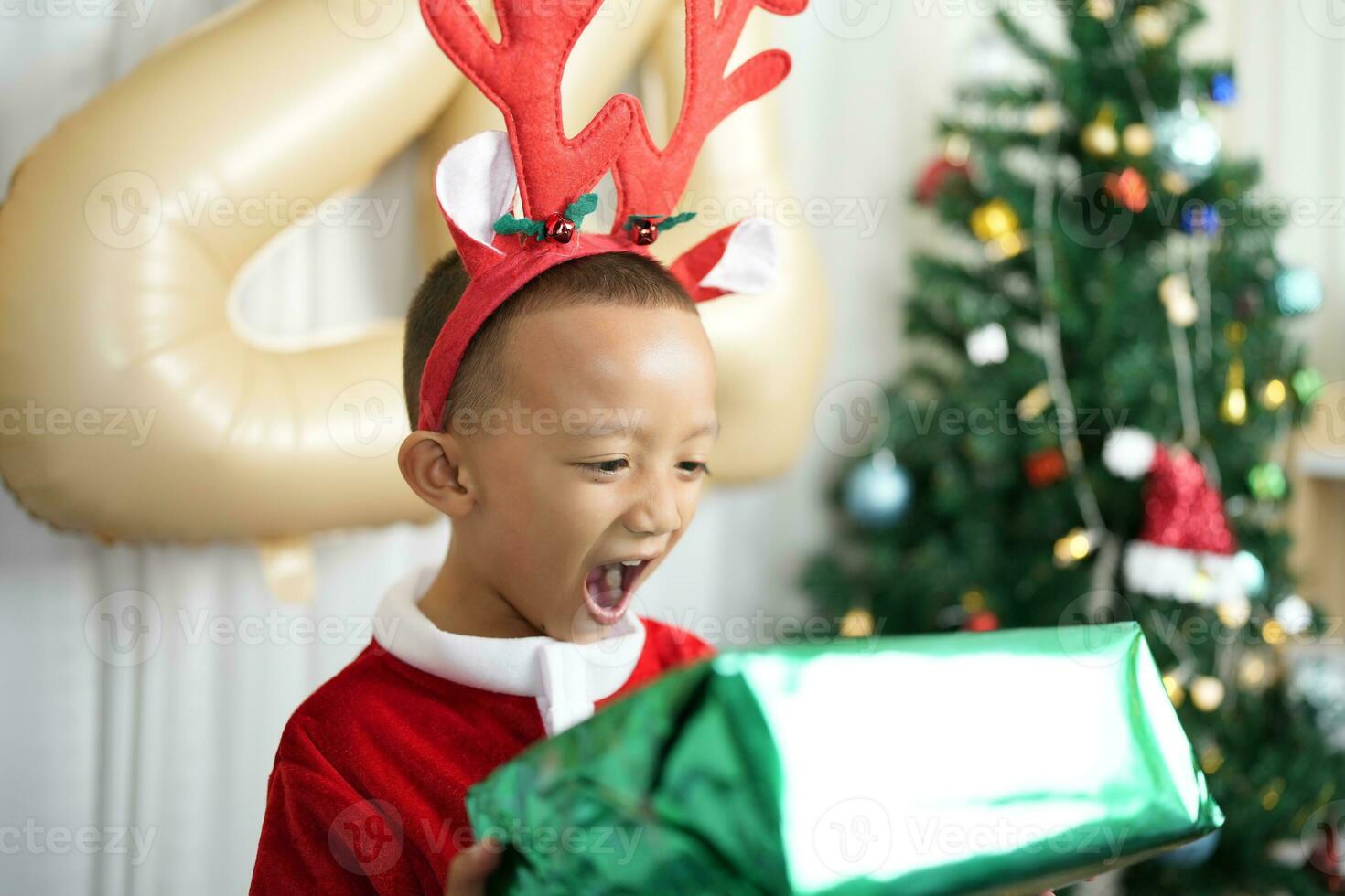 Merry Christmas 2024 concept Boy receives a gift from his mother at christmas photo