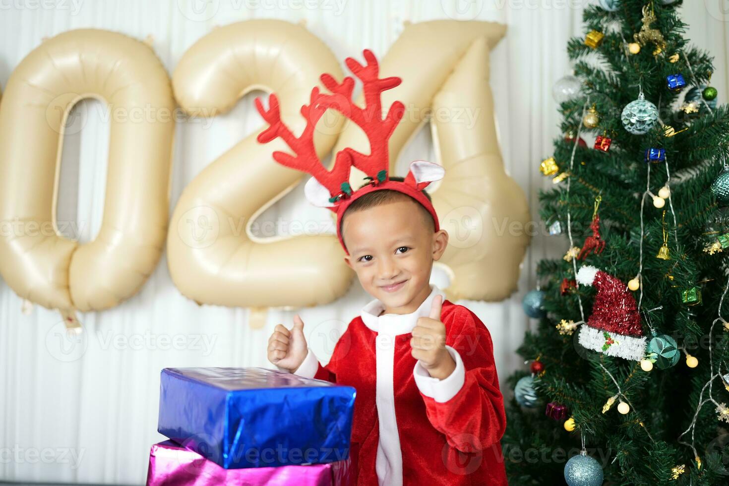 Merry Christmas 2024 concept Boy receives a gift from his mother at christmas photo