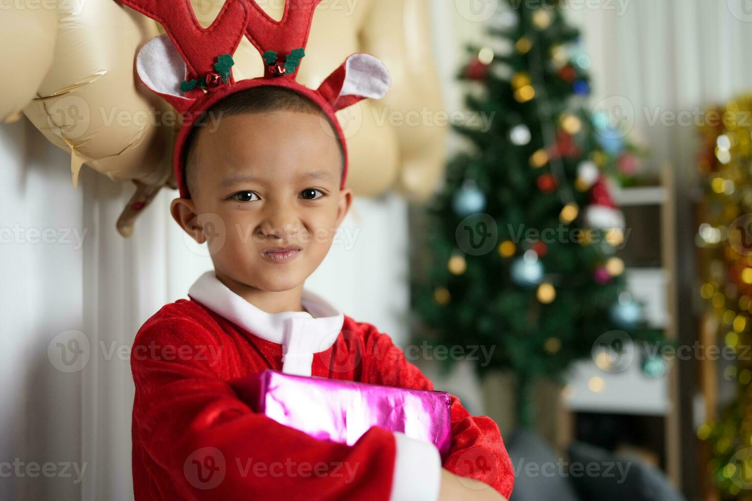 Merry Christmas 2024 concept Boy receives a gift from his mother at christmas photo