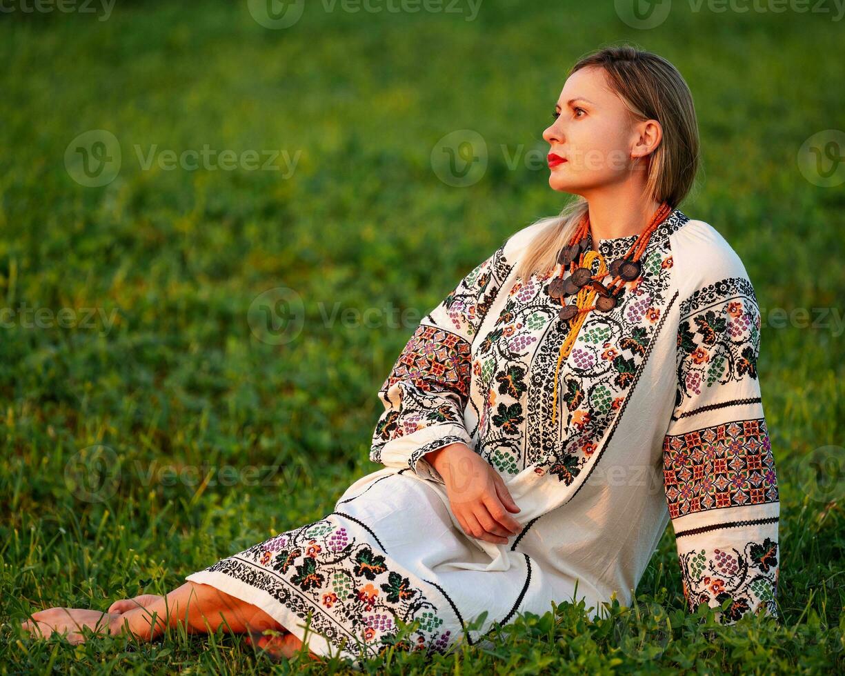 Embroidered and unique petticoat, a girl walks barefoot in the field in an embroidered shirt. photo