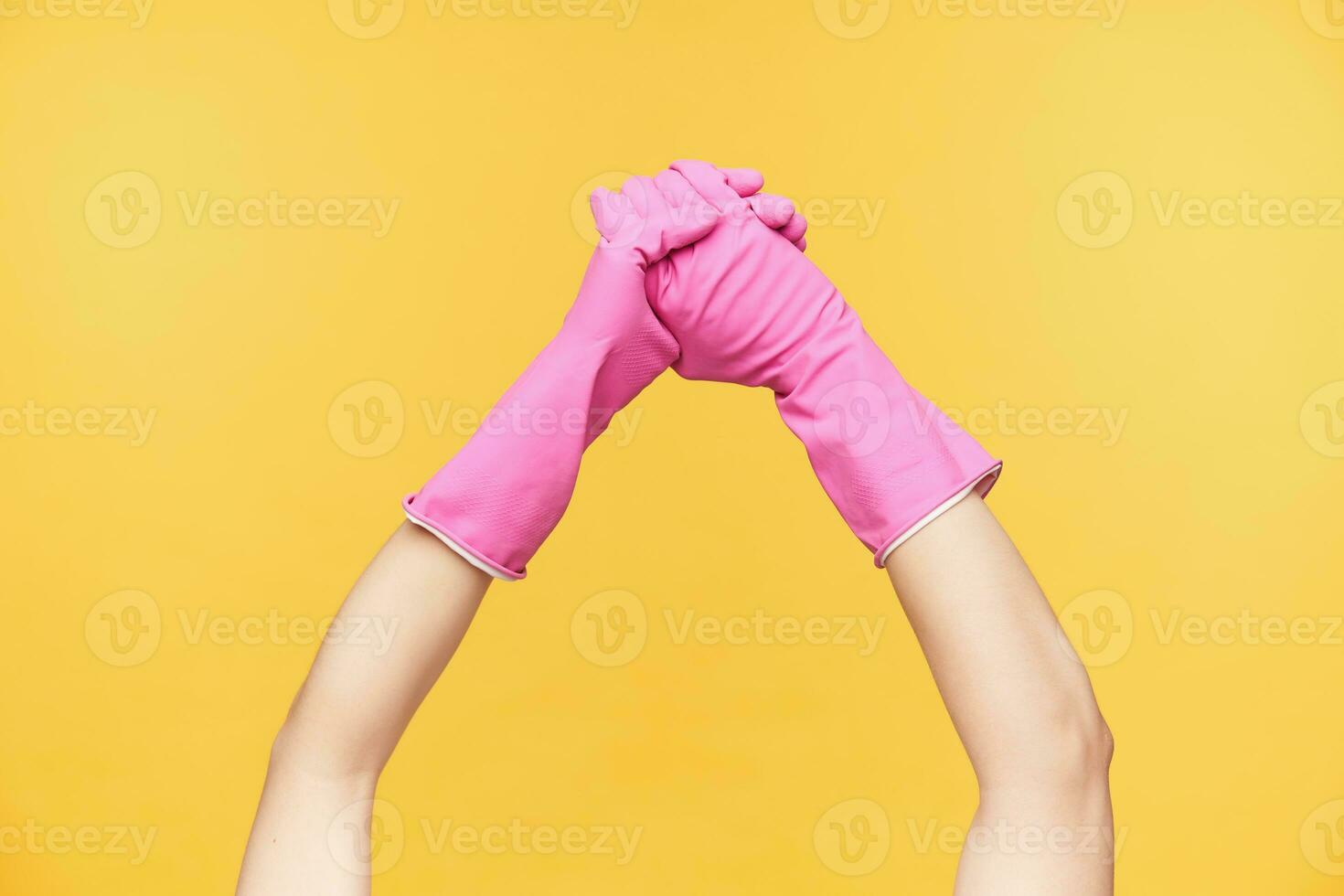recortado joven mujer manos en rosado guantes siendo cruzado mientras Lavado manos con jabón, aislado terminado naranja antecedentes. humano manos y limpieza concepto foto
