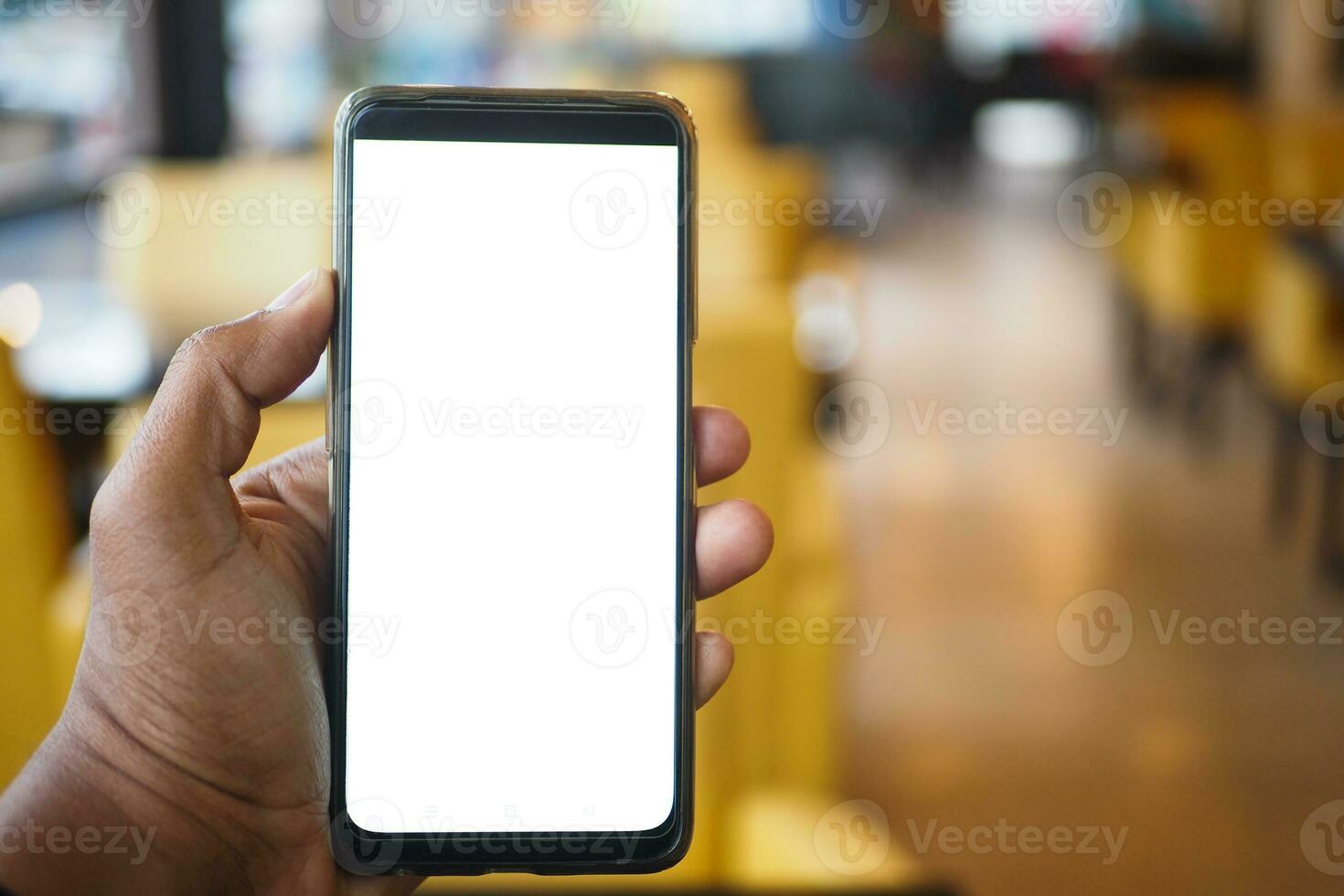 mano de hombre joven usando un teléfono inteligente con pantalla blanca en el café foto