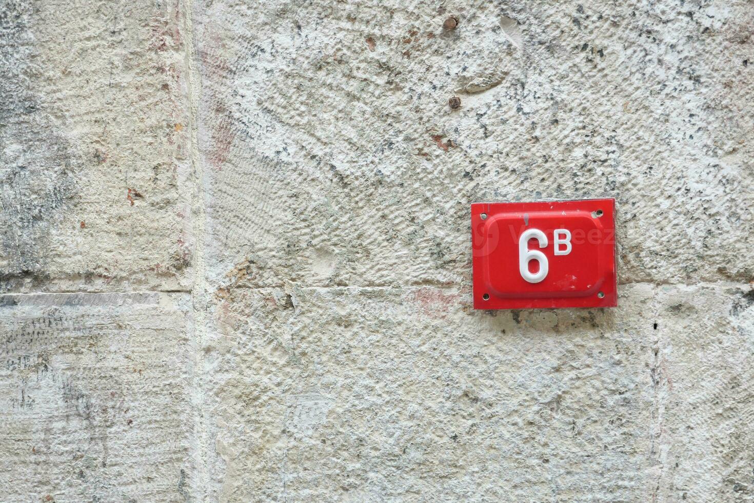 house number six. Decorative lettering on a brick wall. photo