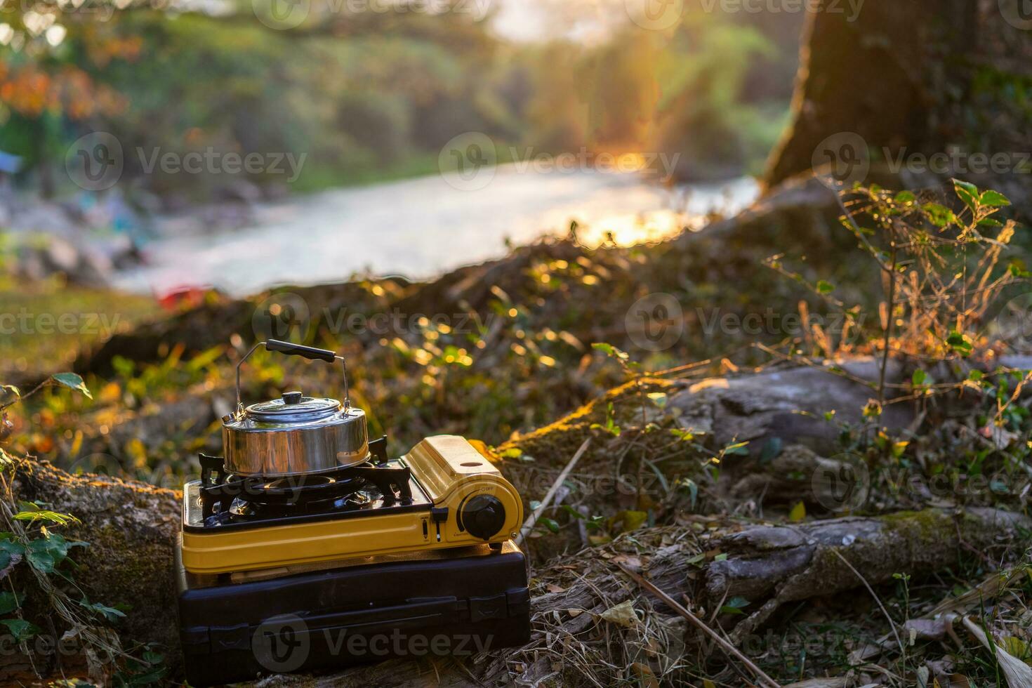 Picnic gas stove and aluminum teapot for boiling water during camping photo