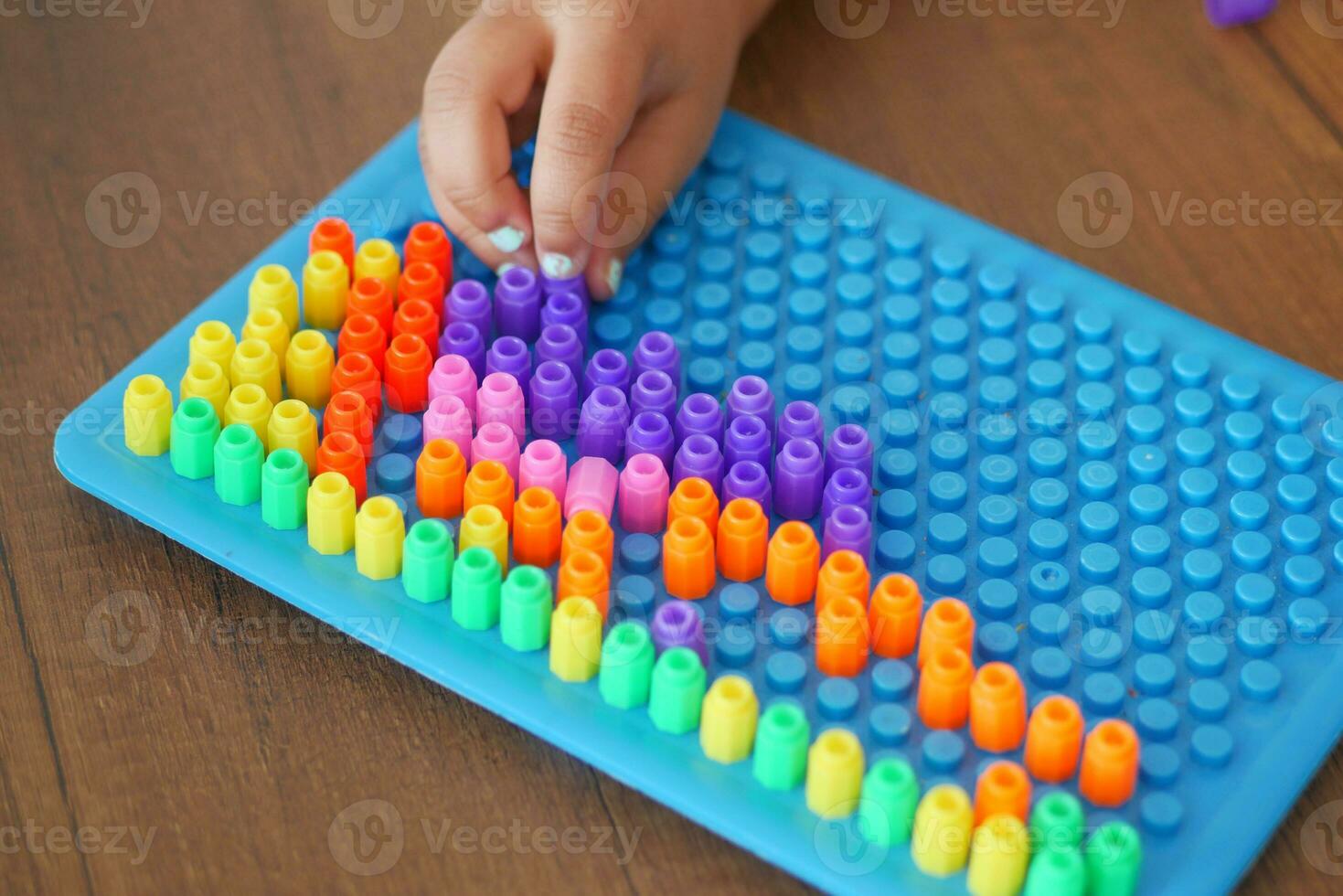 A little girl plays a game, developing motor skills and thinking photo