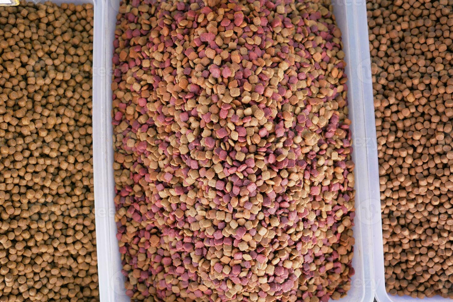 stack of dried cat food display for sale at local market photo