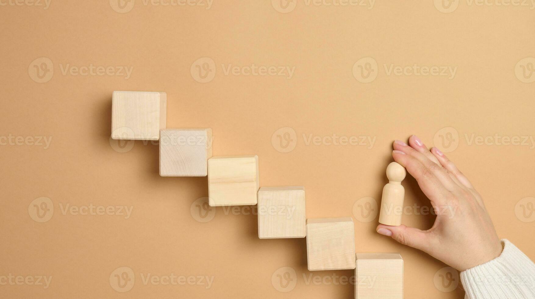 Wooden steps and a woman's hand holding figurines, the concept of career growth photo