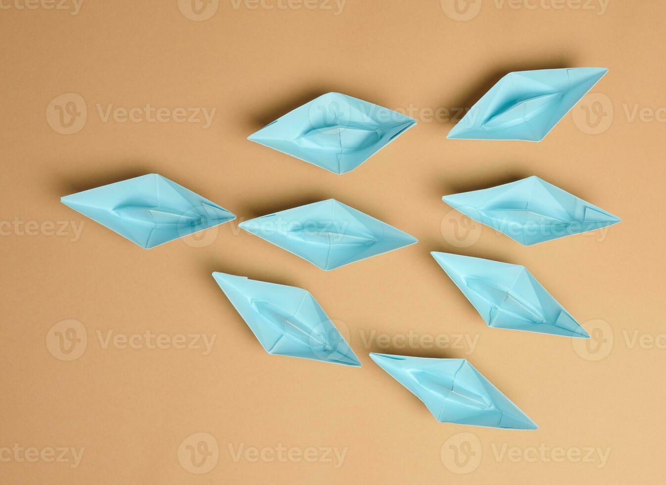 Group of paper boats on a brown background.Concept of a strong leader in a team, manipulation of the masses photo
