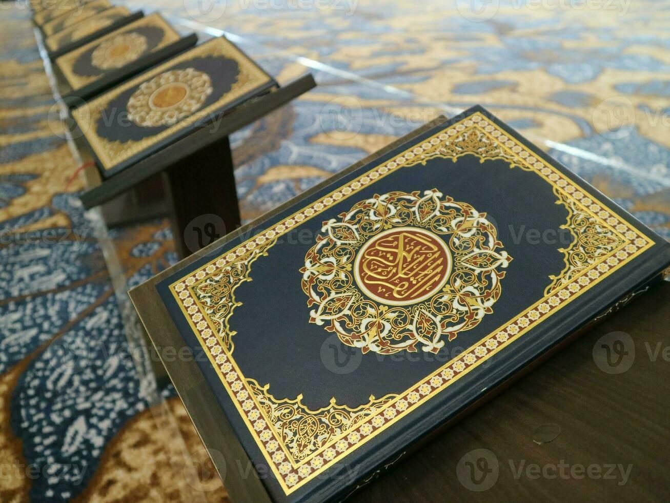 Close up look of holy Quran on tiny table with other quran books on the background. photo