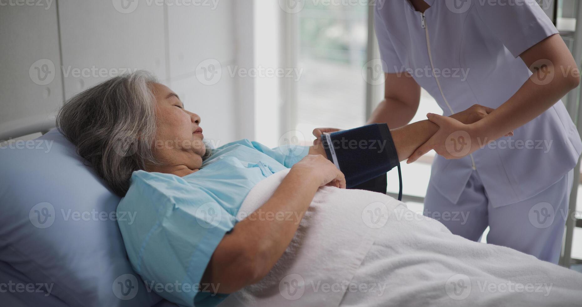 retrato de joven enfermero de un mayor paciente medidas el del paciente sangre presión y corazón tasa,pacientes en hospitales foto