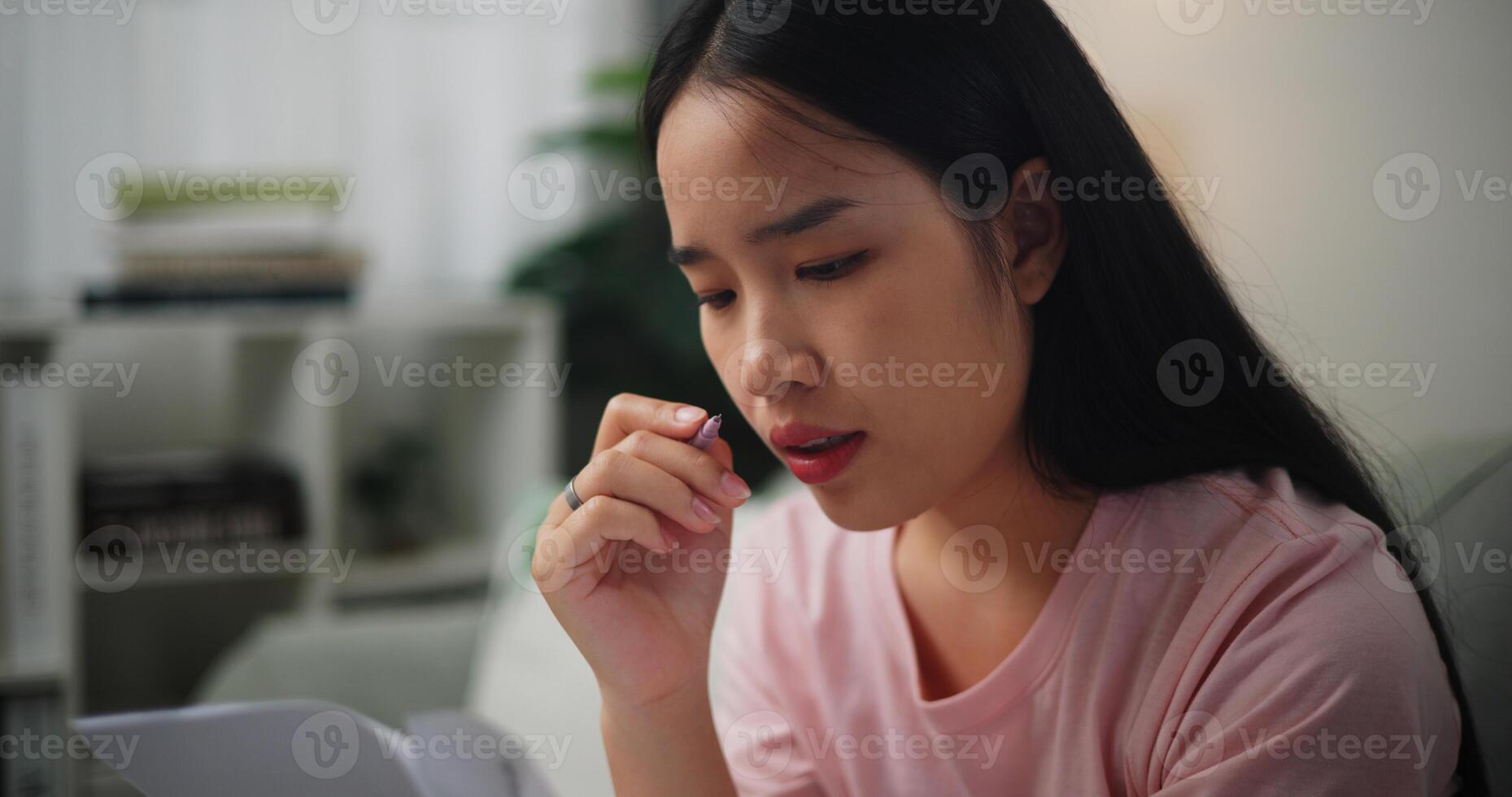 retrato de joven asiático mujer enfocado en calculador presupuesto sentado en sofá a hogar participación papel impuestos cuentas y leyendo financiero informacion,hogar Finanzas foto