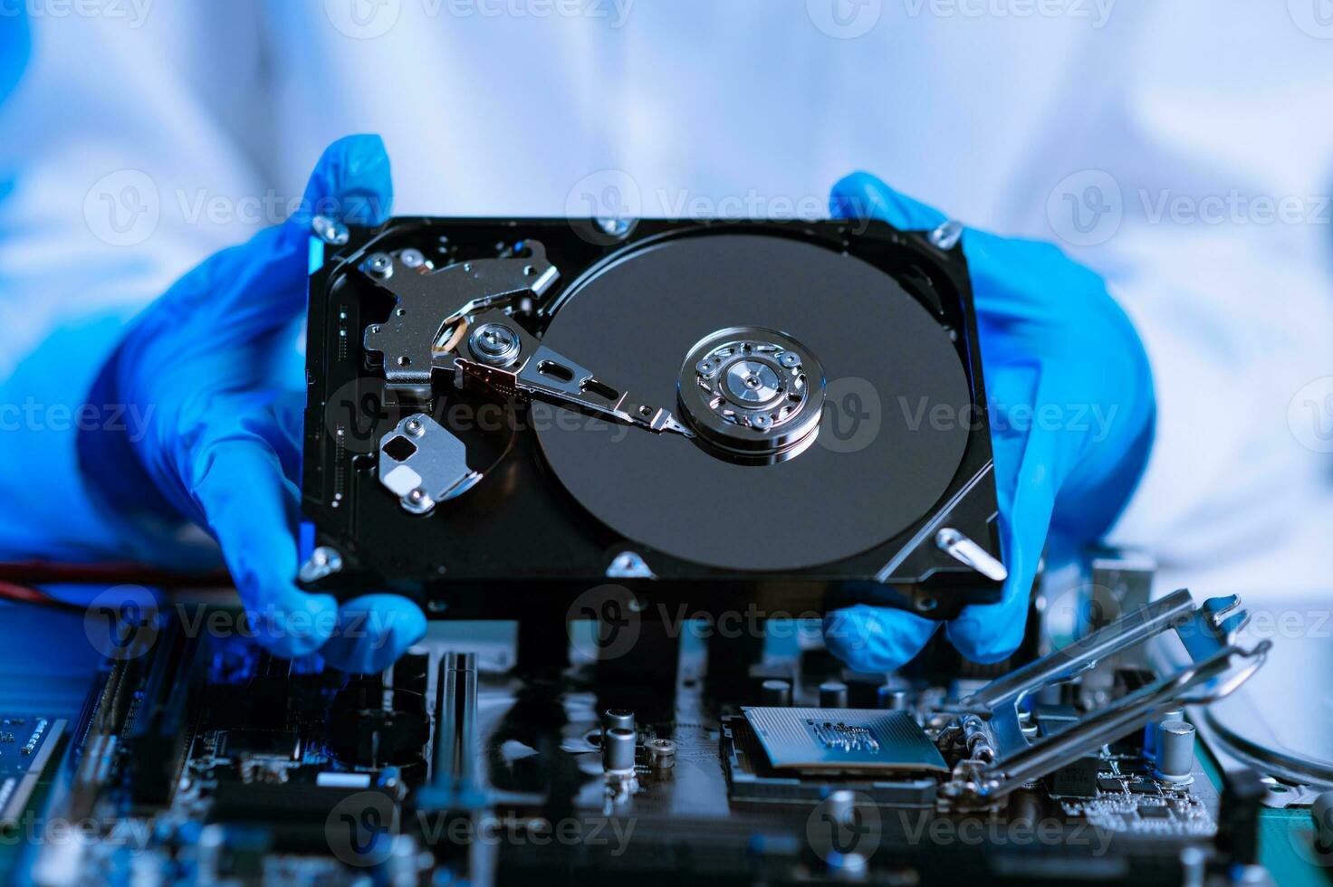 Hard disk drive on the technician's desk and a computer motherboard as a component. the concept of data, hardware, and information technology. photo