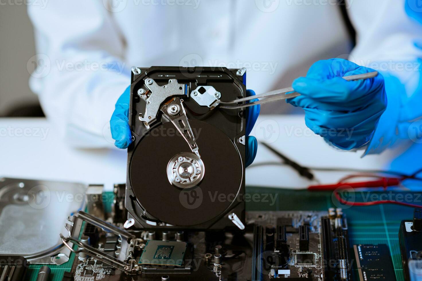 Hard disk drive on the technician's desk and a computer motherboard as a component. the concept of data, hardware, and information technology. photo