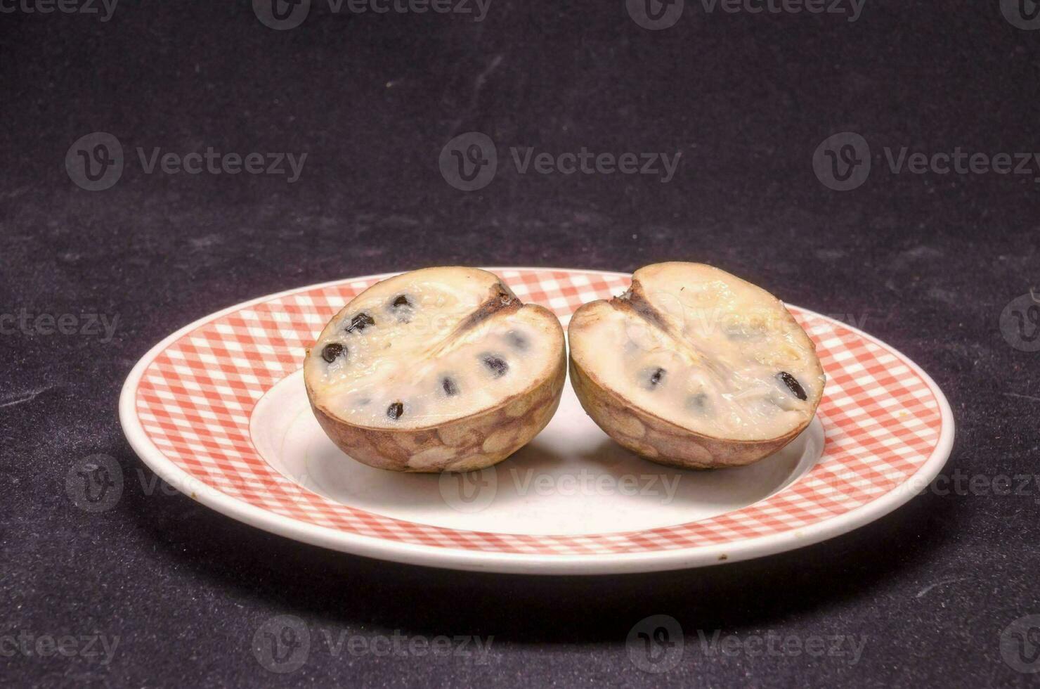 two pieces of fruit on a plate with a checkered pattern photo