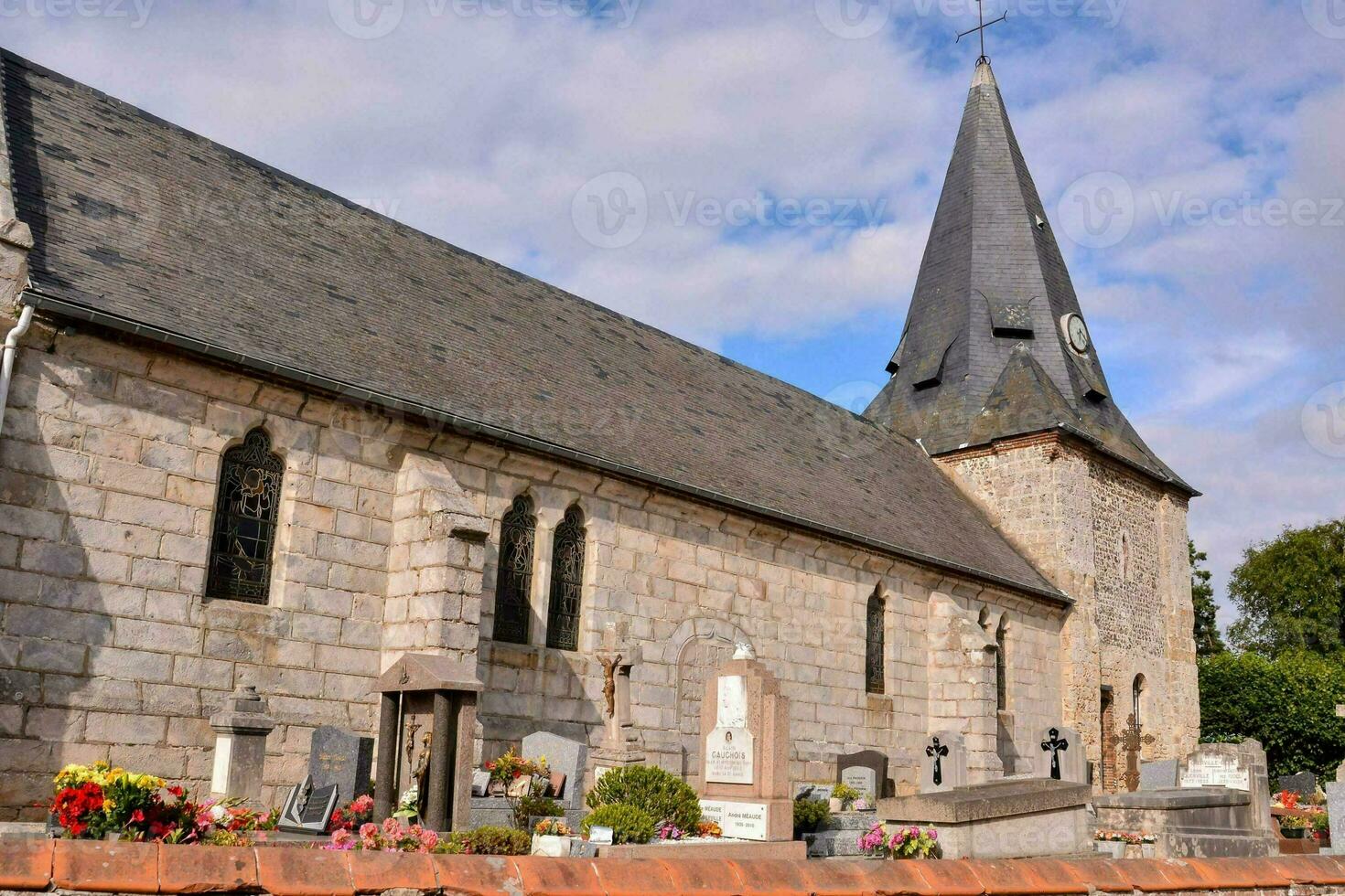 a church with a steeple and a graveyard photo