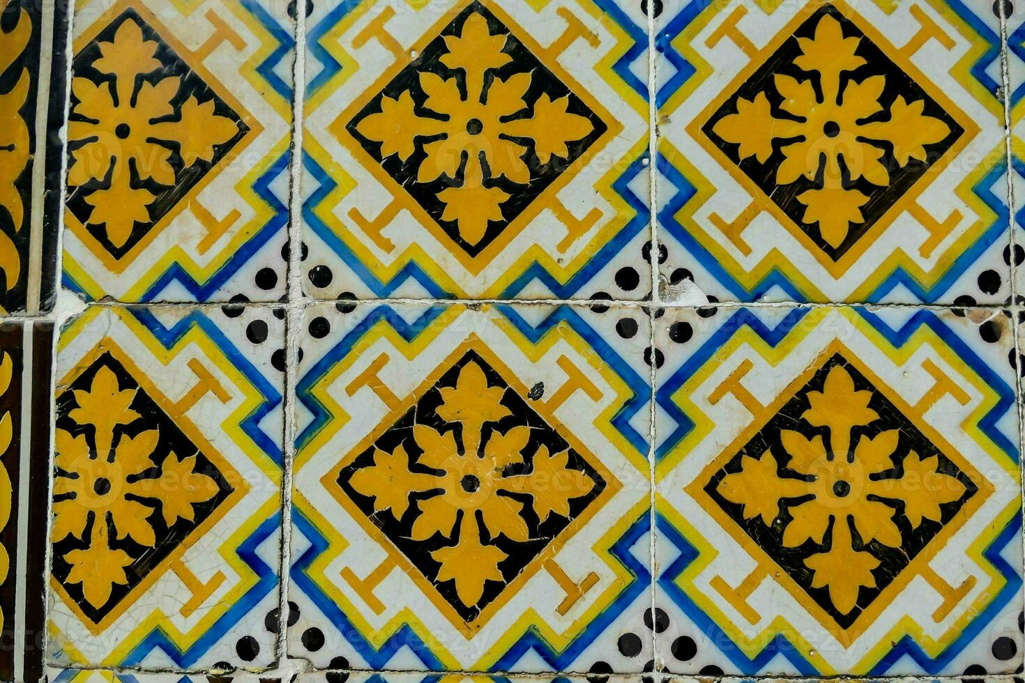 a blue and yellow tile with a design on it photo