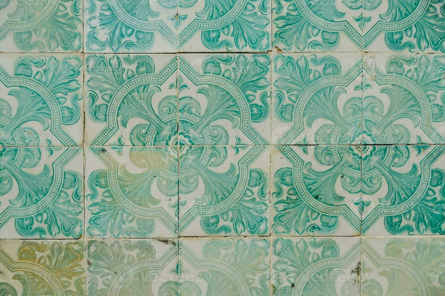 a close up of a tile wall with green and white designs photo