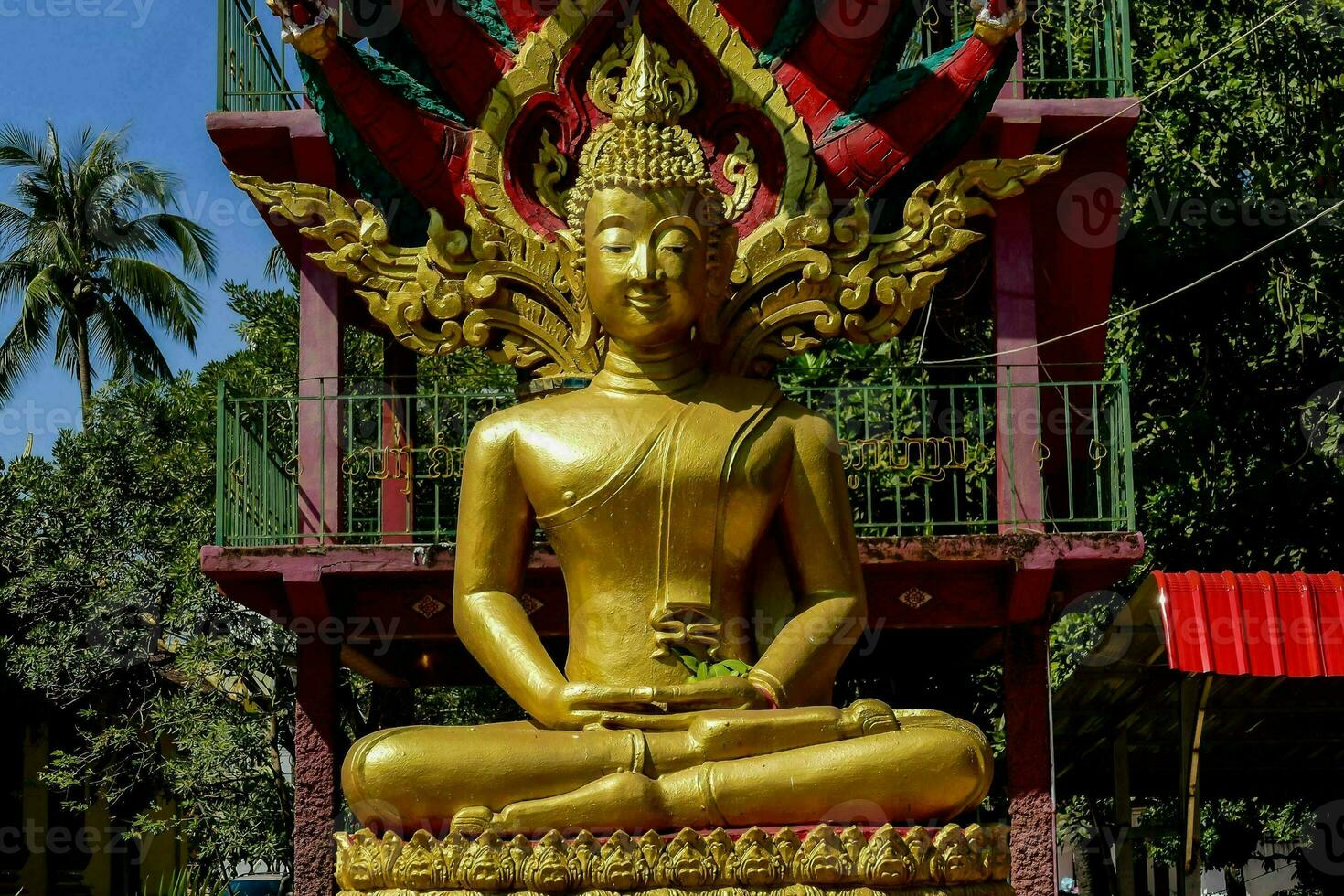 a large golden buddha statue in front of a building photo