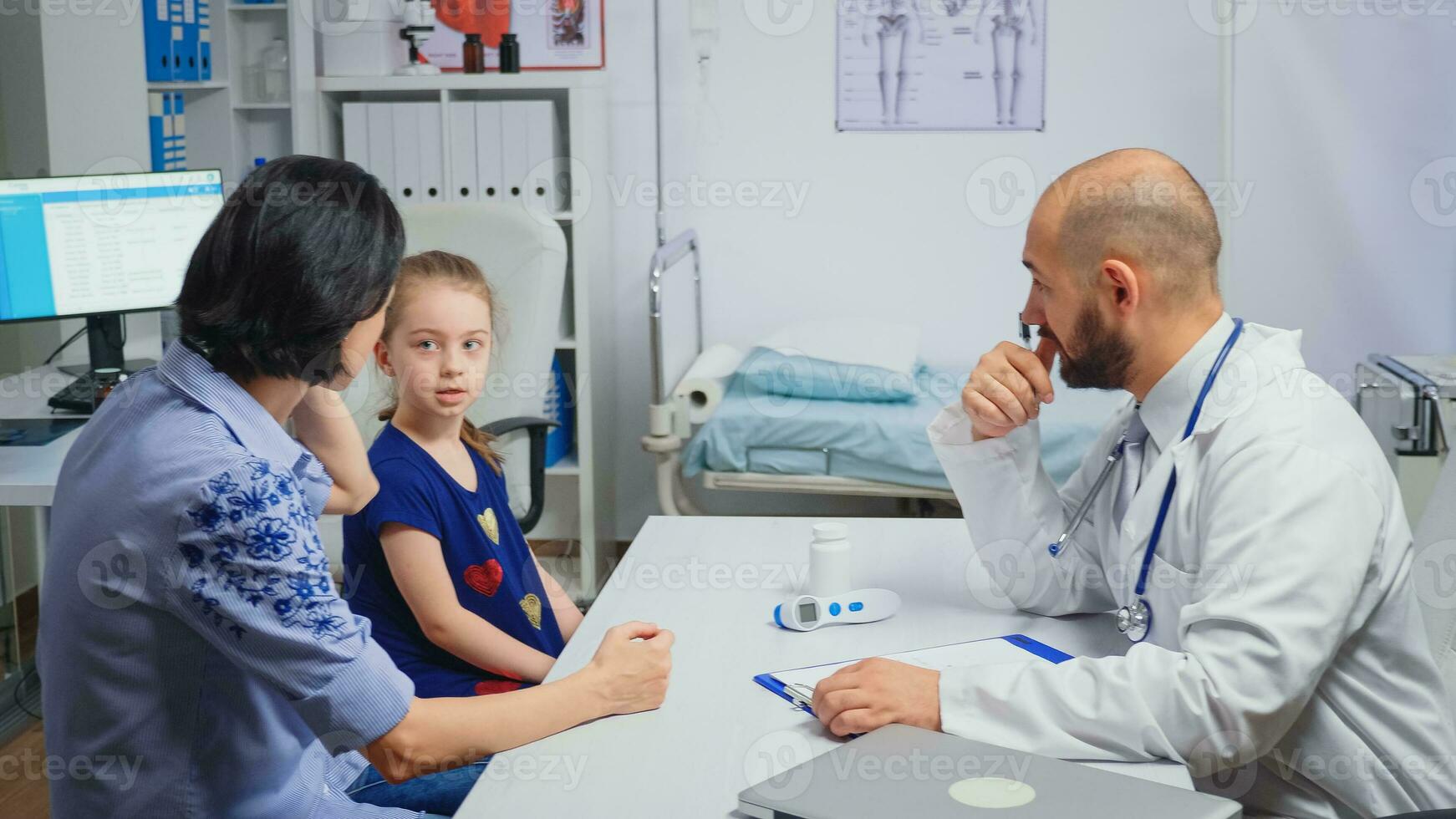 Sitting at desk and writing treatment for ill child. Healthcare practitioner physician specialist in medicine providing health care services radiographic treatment examination in hospital cabinet photo