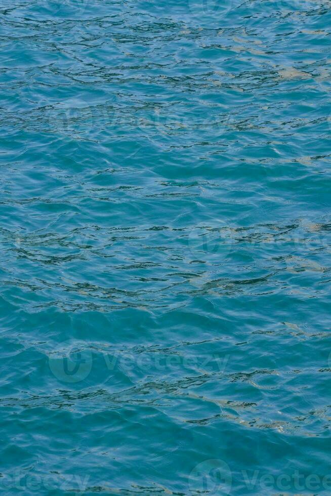 the water is blue and clear with ripples photo