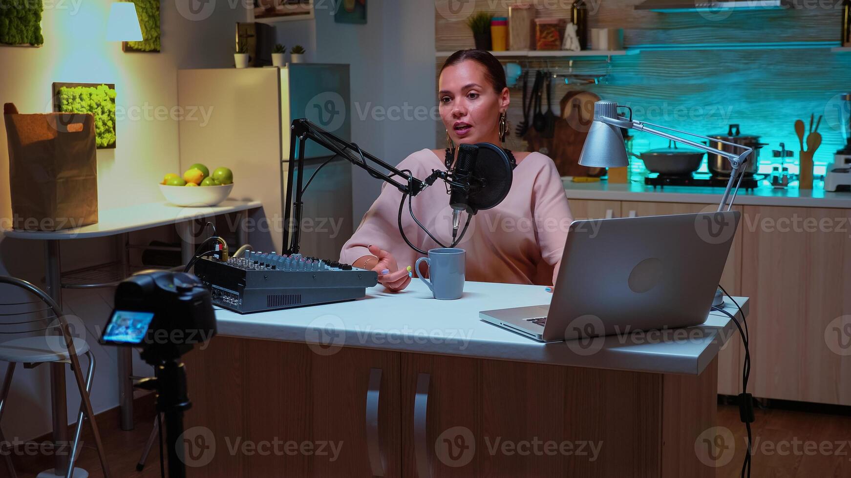 Person speaking about her life during podcast in home studio with neon light behind her. Creative online show Onair production internet broadcast host streaming live content, recording digital social media communication photo