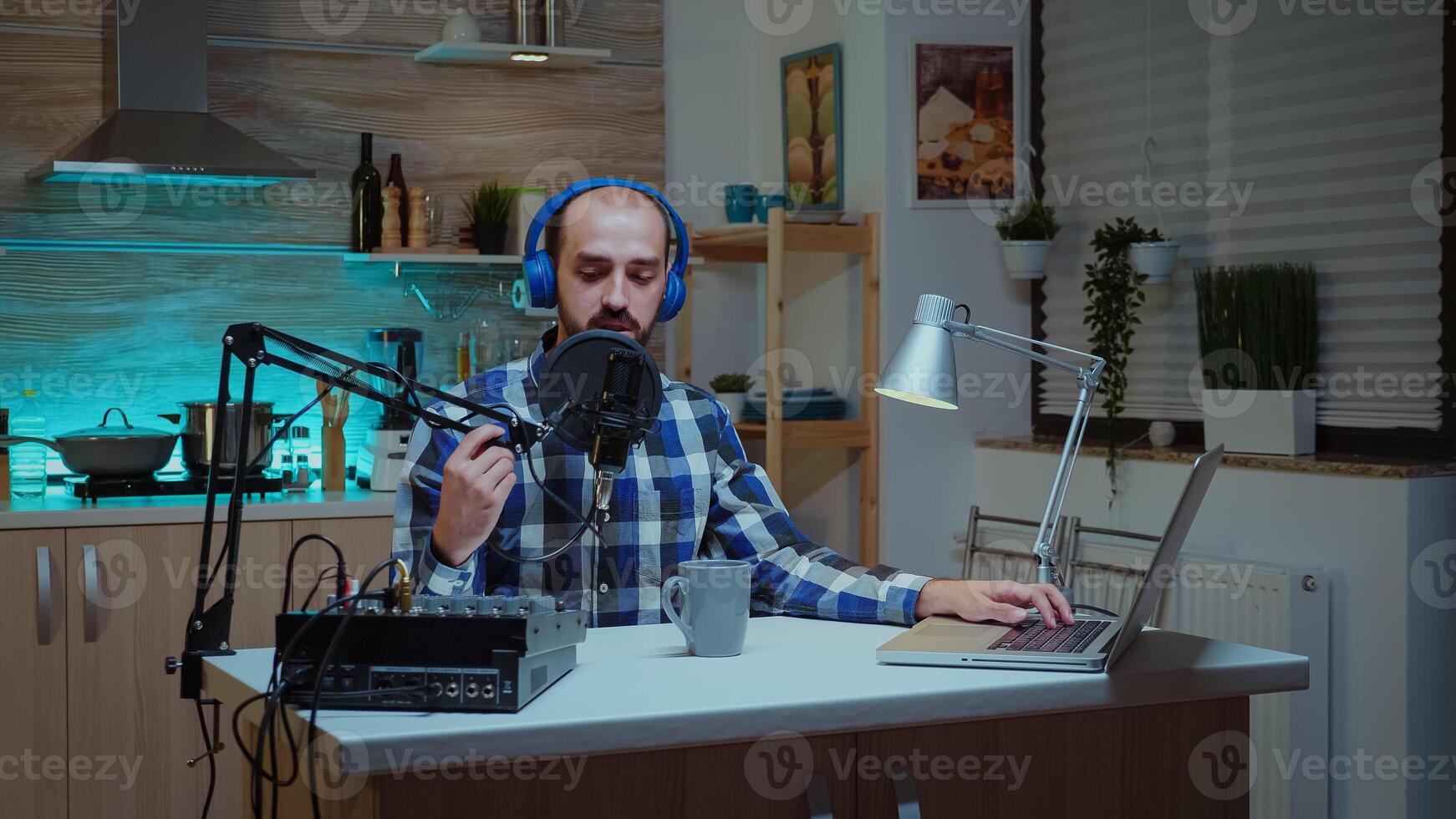 Man blogger wearing headphones and talking about his lifestyle during podcast from home. Creative online show Onair production internet broadcast host streaming live content, recording digital social media communication photo