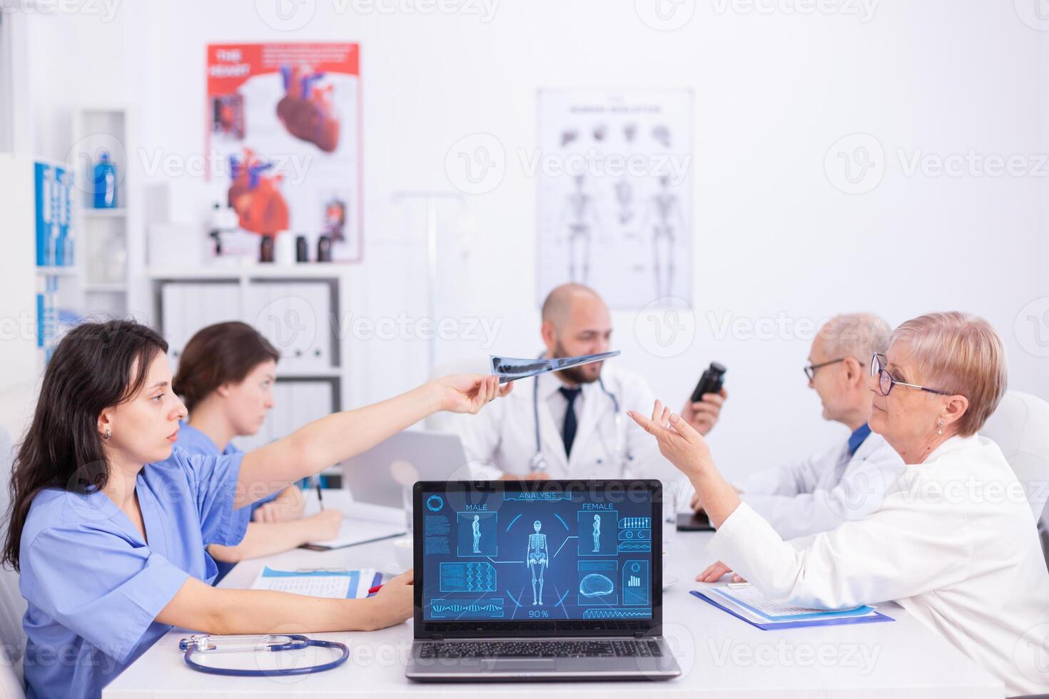 Group of medical staff discussing in hospital meeting room about patient radiography. Clinic expert therapist talking with colleagues about disease, medicine professional photo