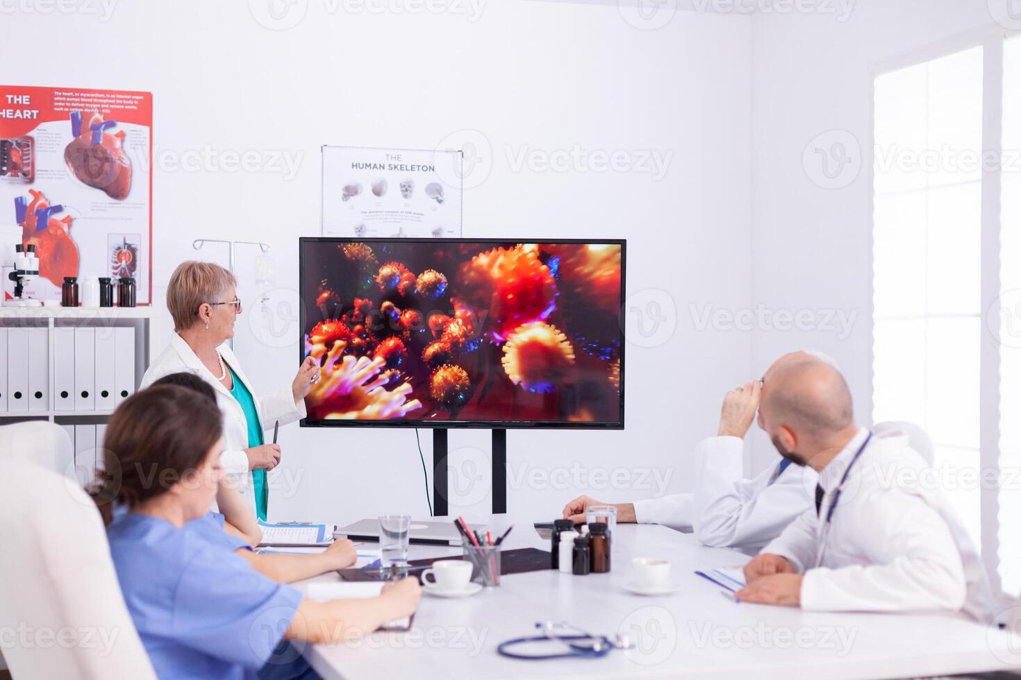 Medical specialist talking about vaccine for coronavirus pandemic during medical meeting with staff. Doctor discussing with colleagues about global pandemic because of dangerous virus, symptoms. photo