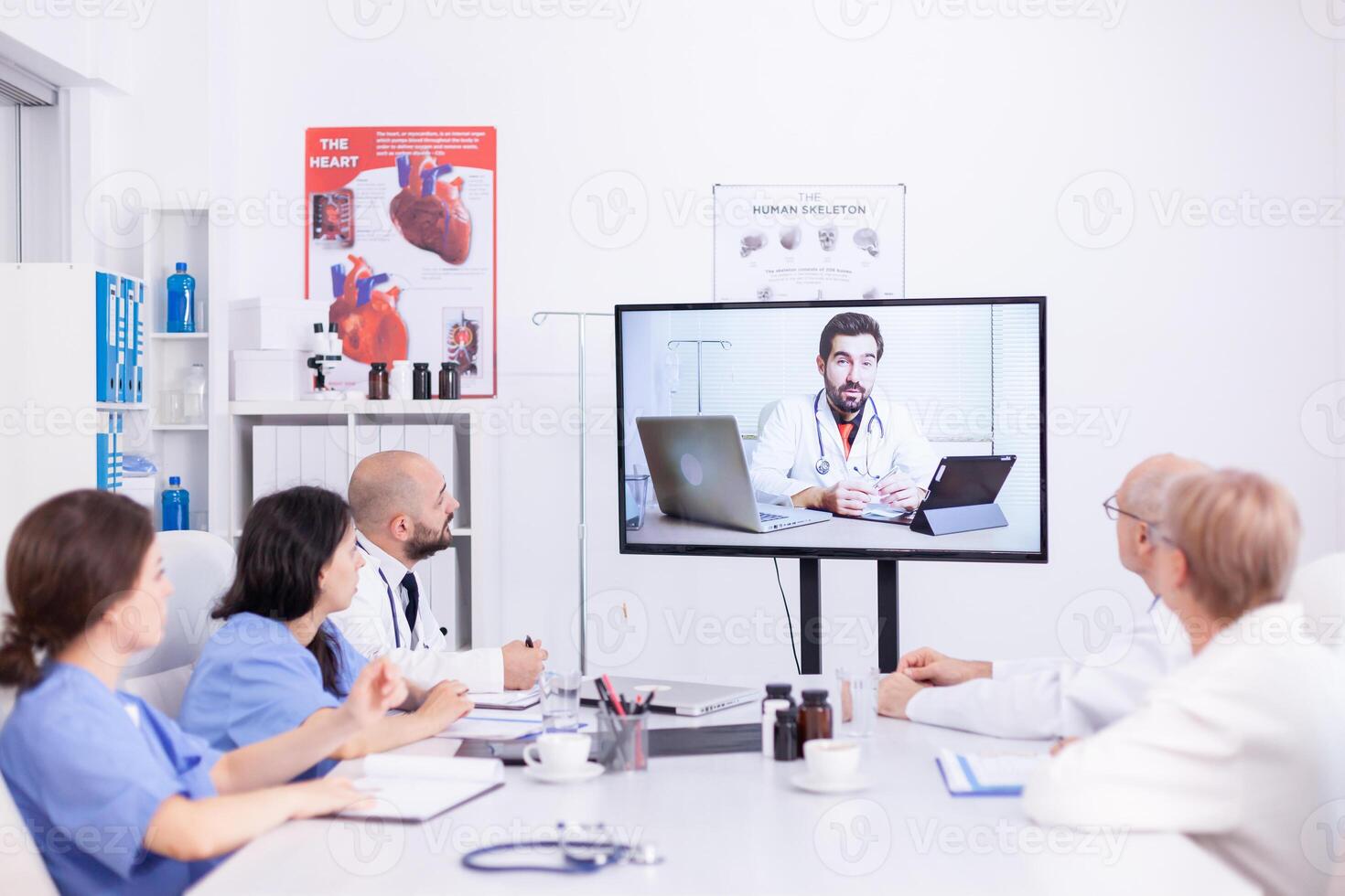 Videoconference of hospital team with expert doctor. Medicine staff using internet during online meeting with therapist doctor for expertise. photo