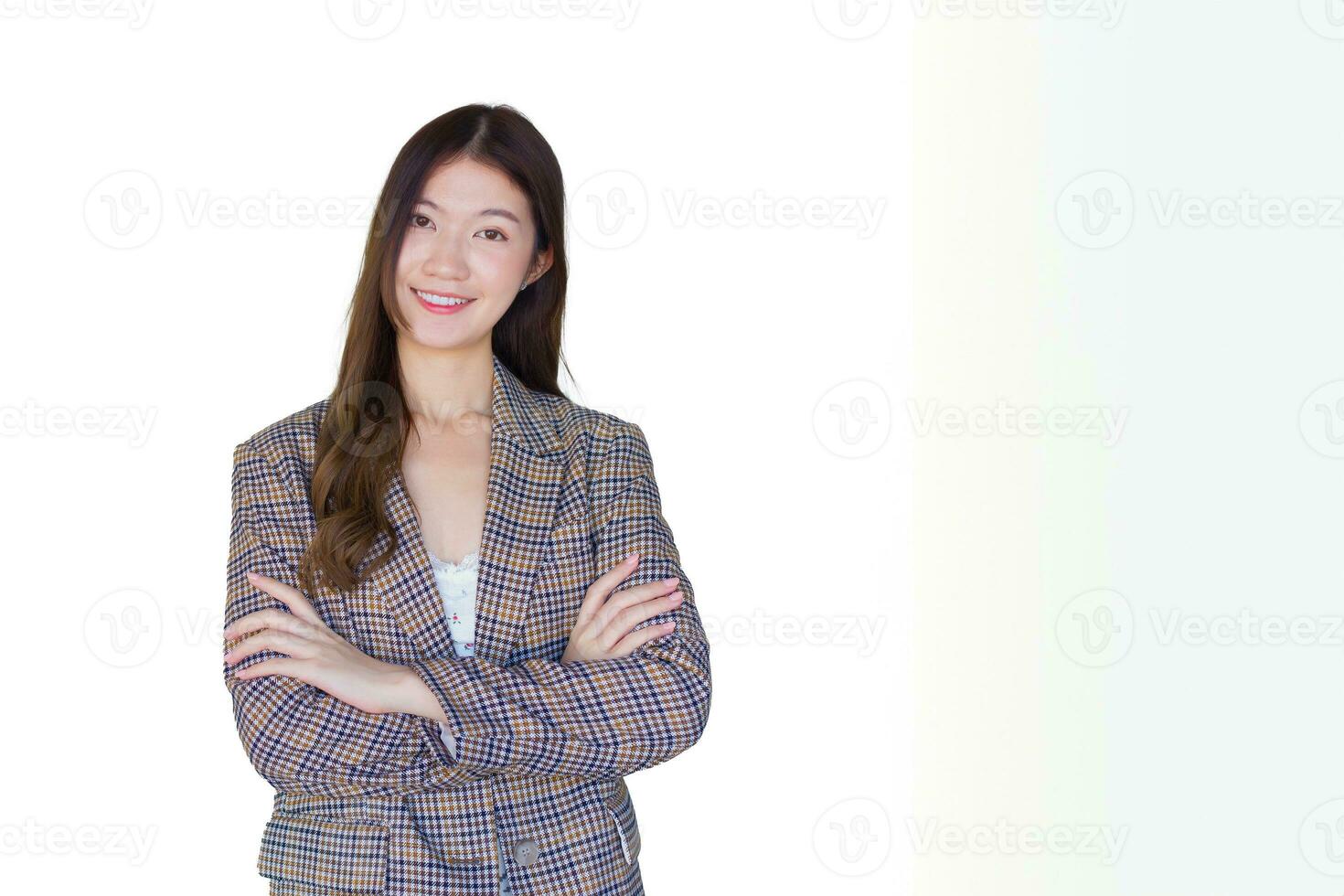 Adult Asian professional woman with black long hair wearing plaid suit stand with arms crossed and pretty smiling looking at camera is present product on white background. photo