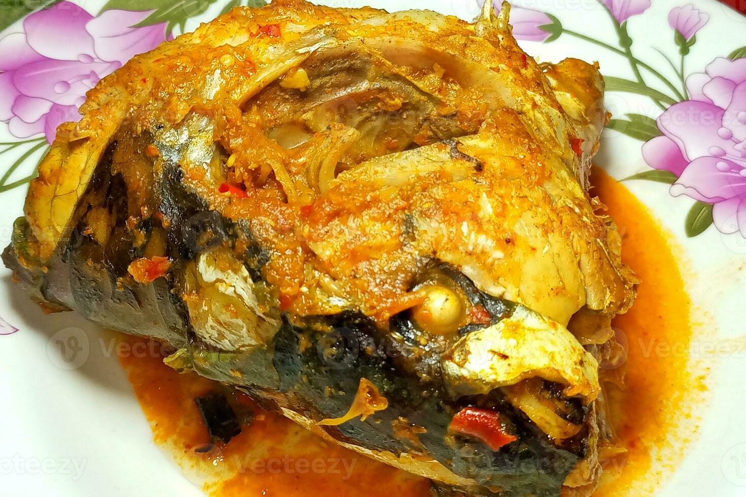 Fish head cooked with spices on a plate photo