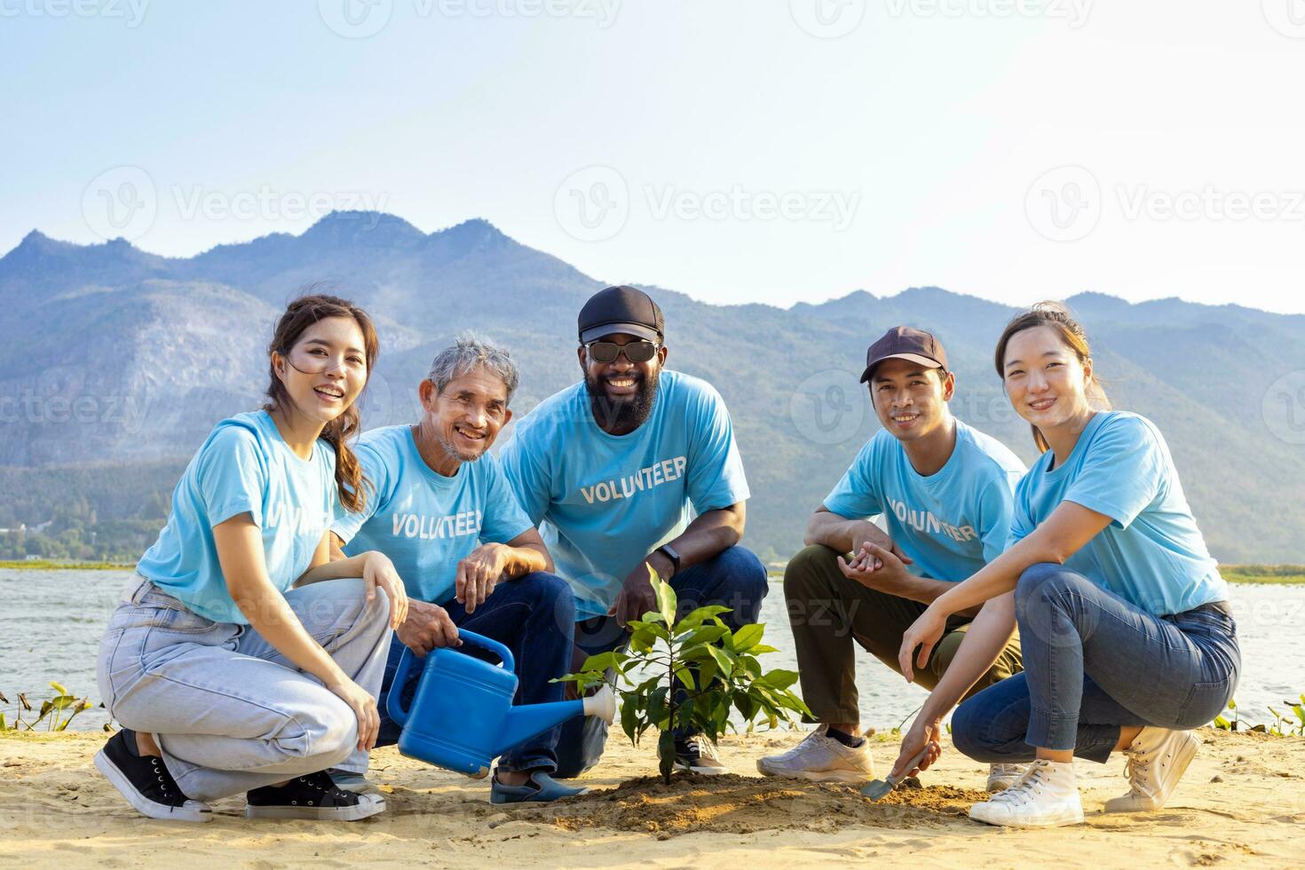 Team of young and diversity volunteer worker group enjoy charitable social work outdoor in tree forest planting NGO work for fighting climate change and global warming in coastline habitat project photo