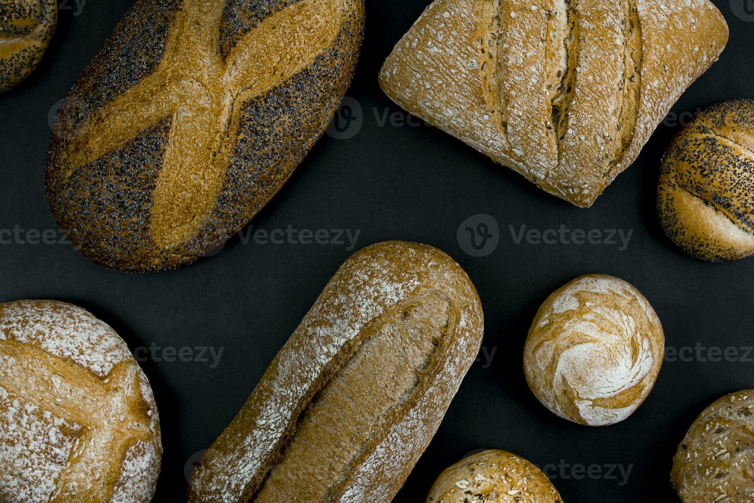 Different types of freshly baked bread on a black background. photo