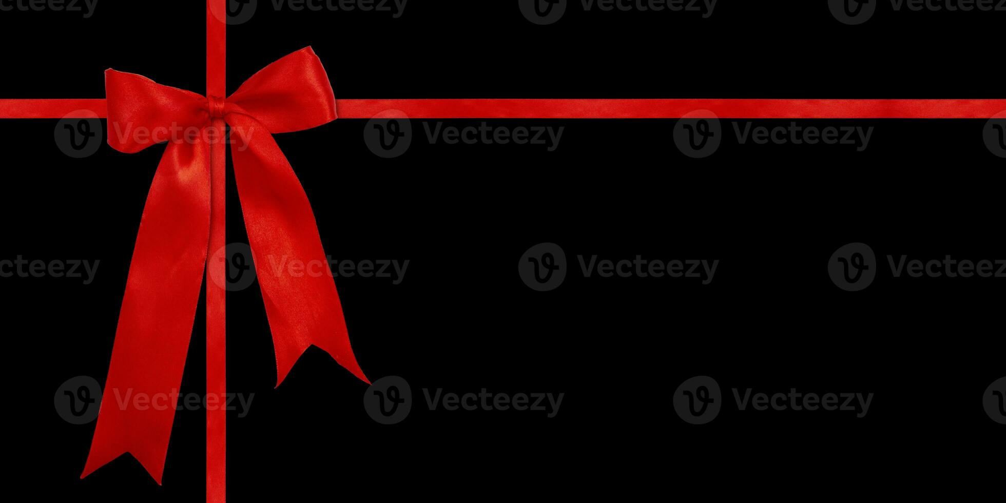 Gift wrapping design with red satin bow isolated on black background. Preparation for the holiday. photo