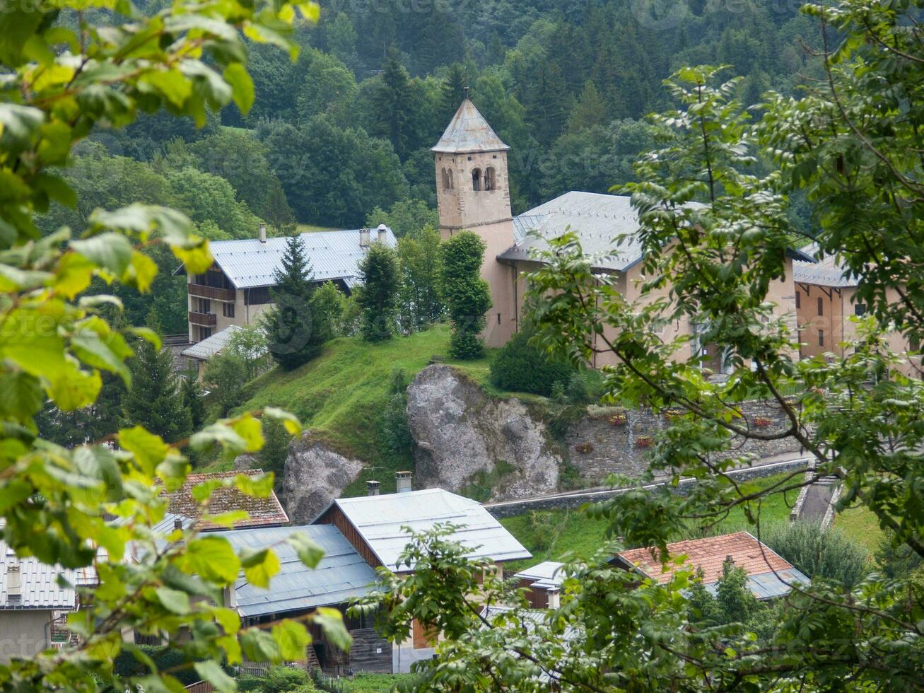 un pequeño pueblo con un Iglesia en parte superior de un colina foto