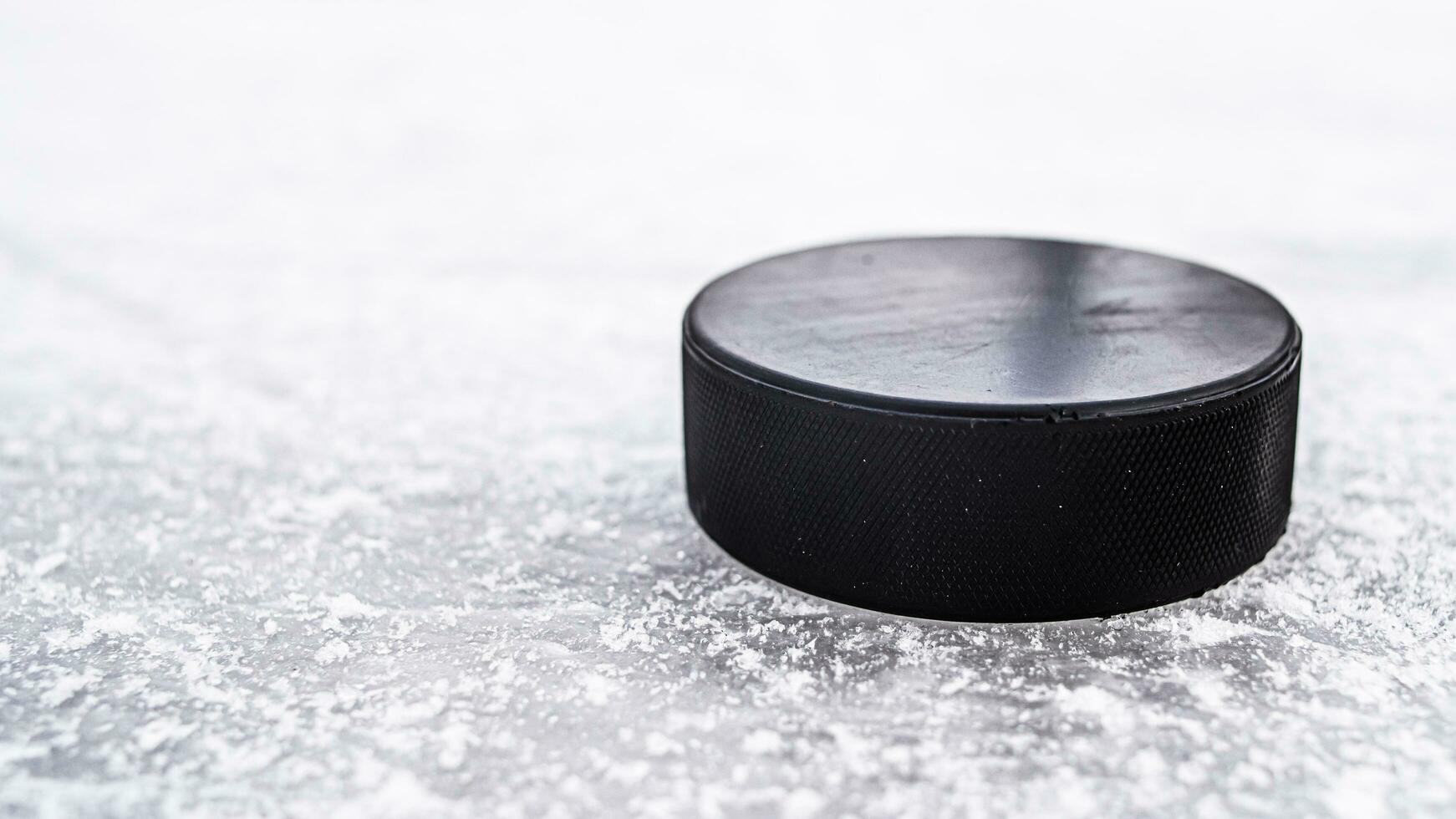 hockey puck lies on the snow macro photo