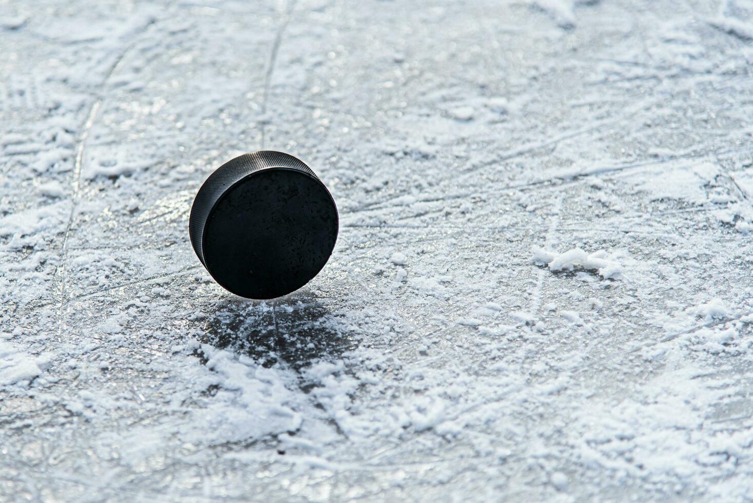 hockey puck lies on the snow close-up photo