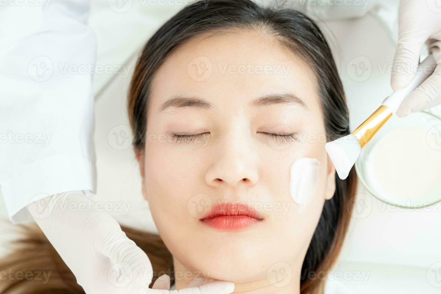 hermosa mujer recibir spa y tratamiento piel de rostro. cara de un sano mujer aplicar crema. anuncio para piel crema, anti arrugas, bebé rostro, blanqueo, hidratante, apretar poros suero foto