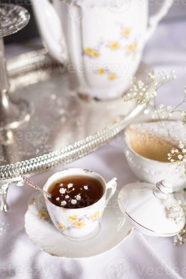 blanco todavía vida con tarta de queso y Gypsophila y taza de té, ligero y aireado foto