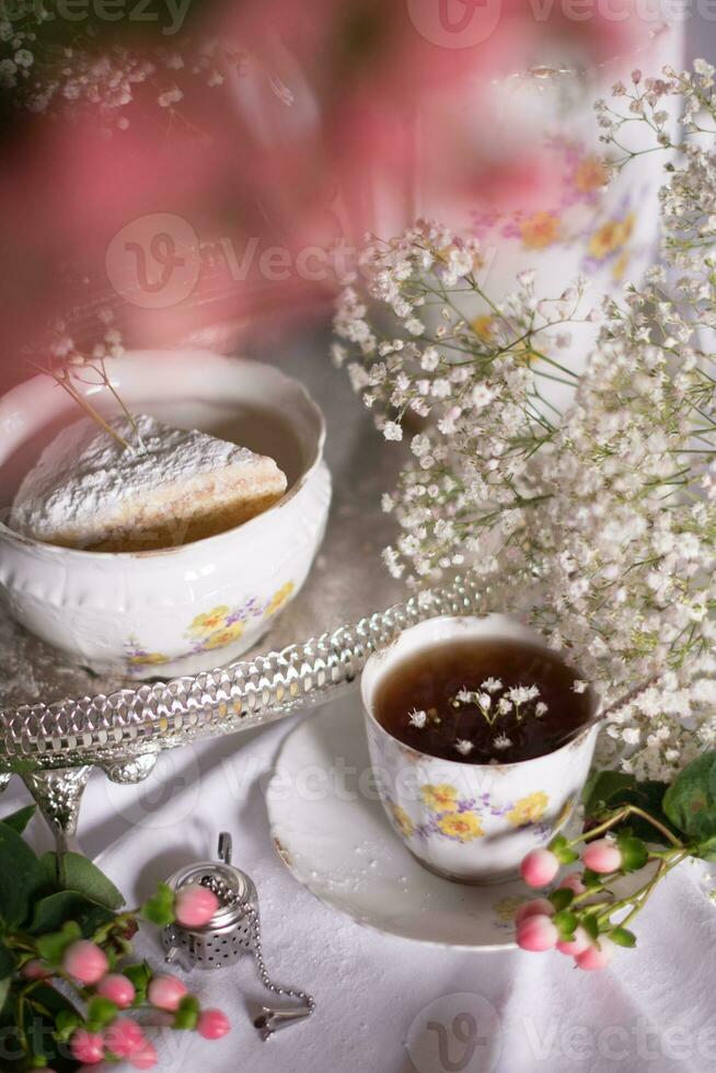 blanco todavía vida con tarta de queso y Gypsophila y taza de té, ligero y aireado foto