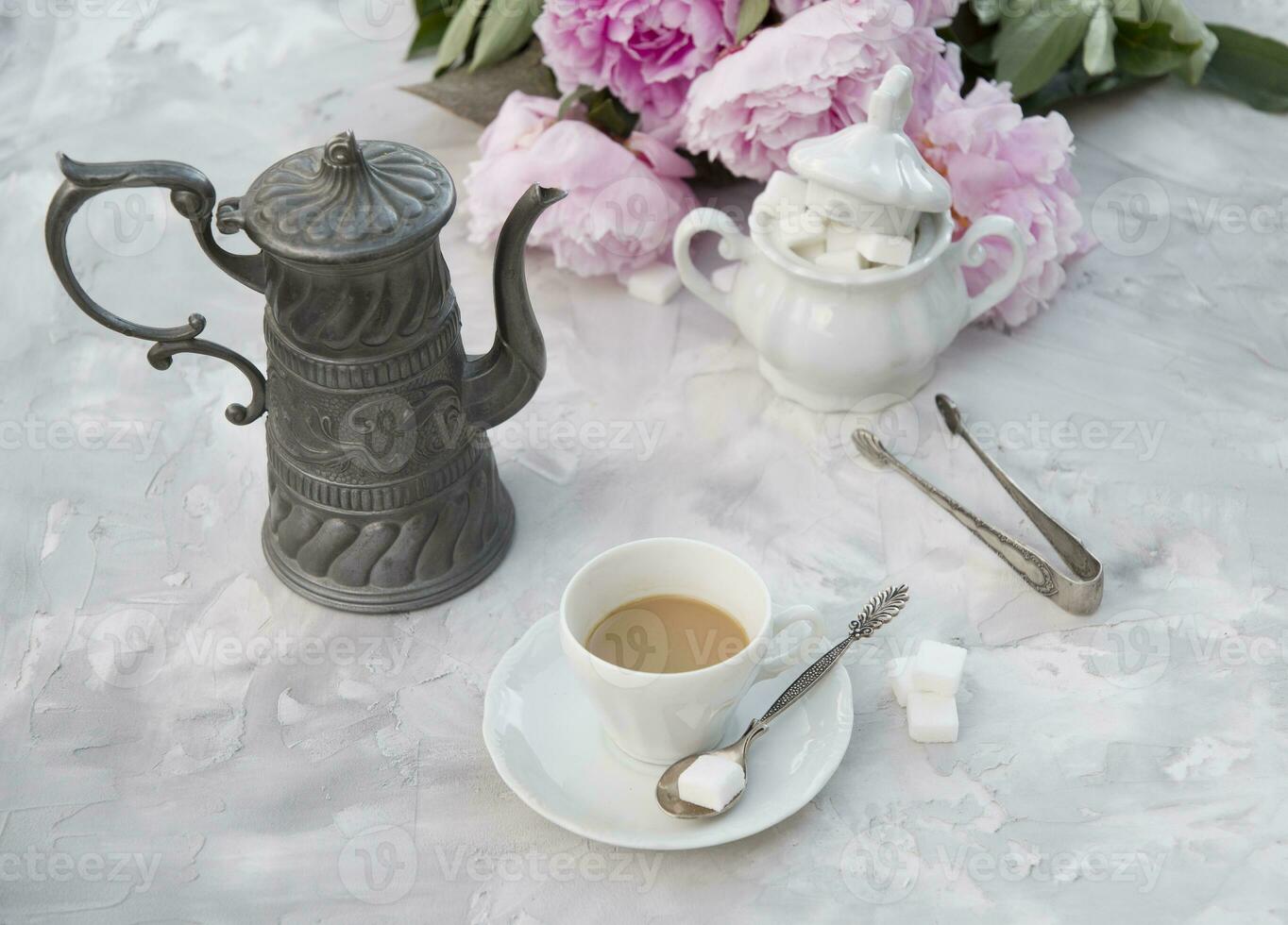 vintage still life with a cup of coffee against a bouquet of pink peonies photo