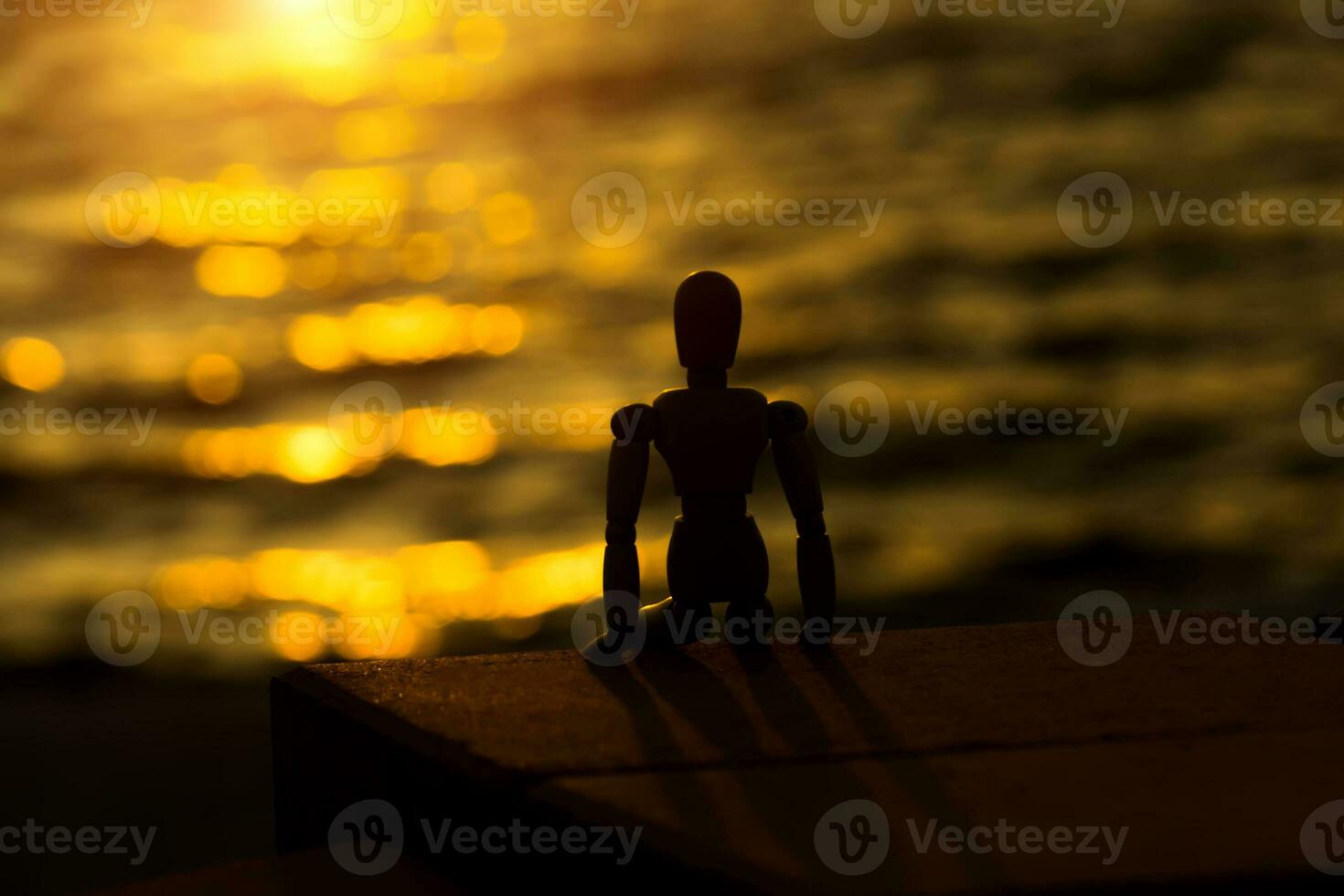 Silhouettes of wooden models feel lonely at sunset. photo