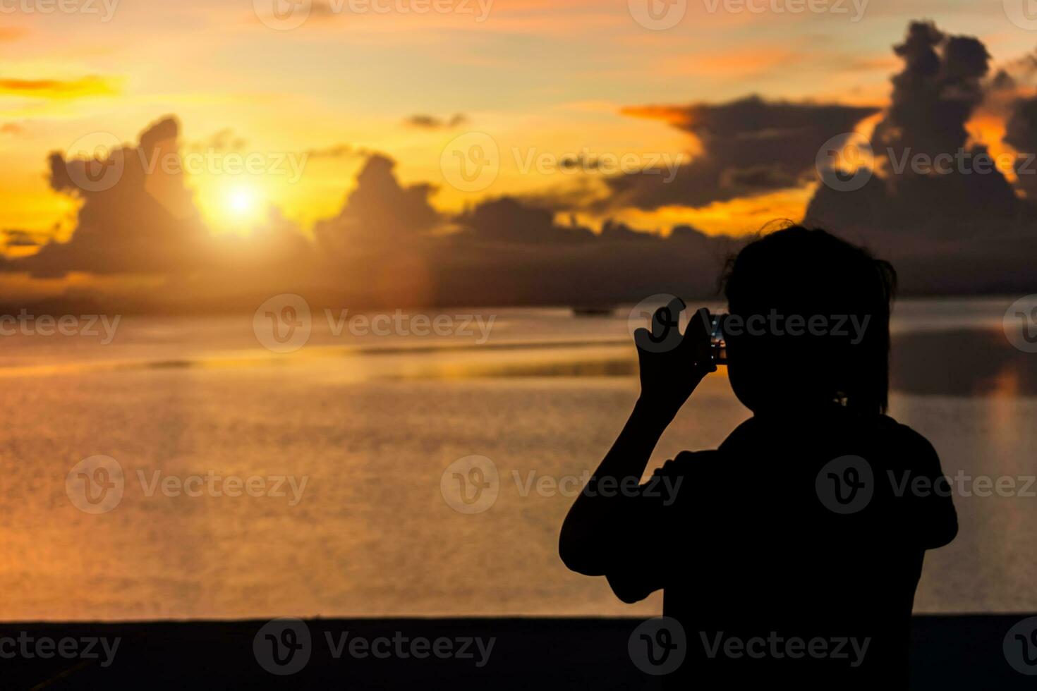 Silhouettes people shooting the sunset at the lake. photo